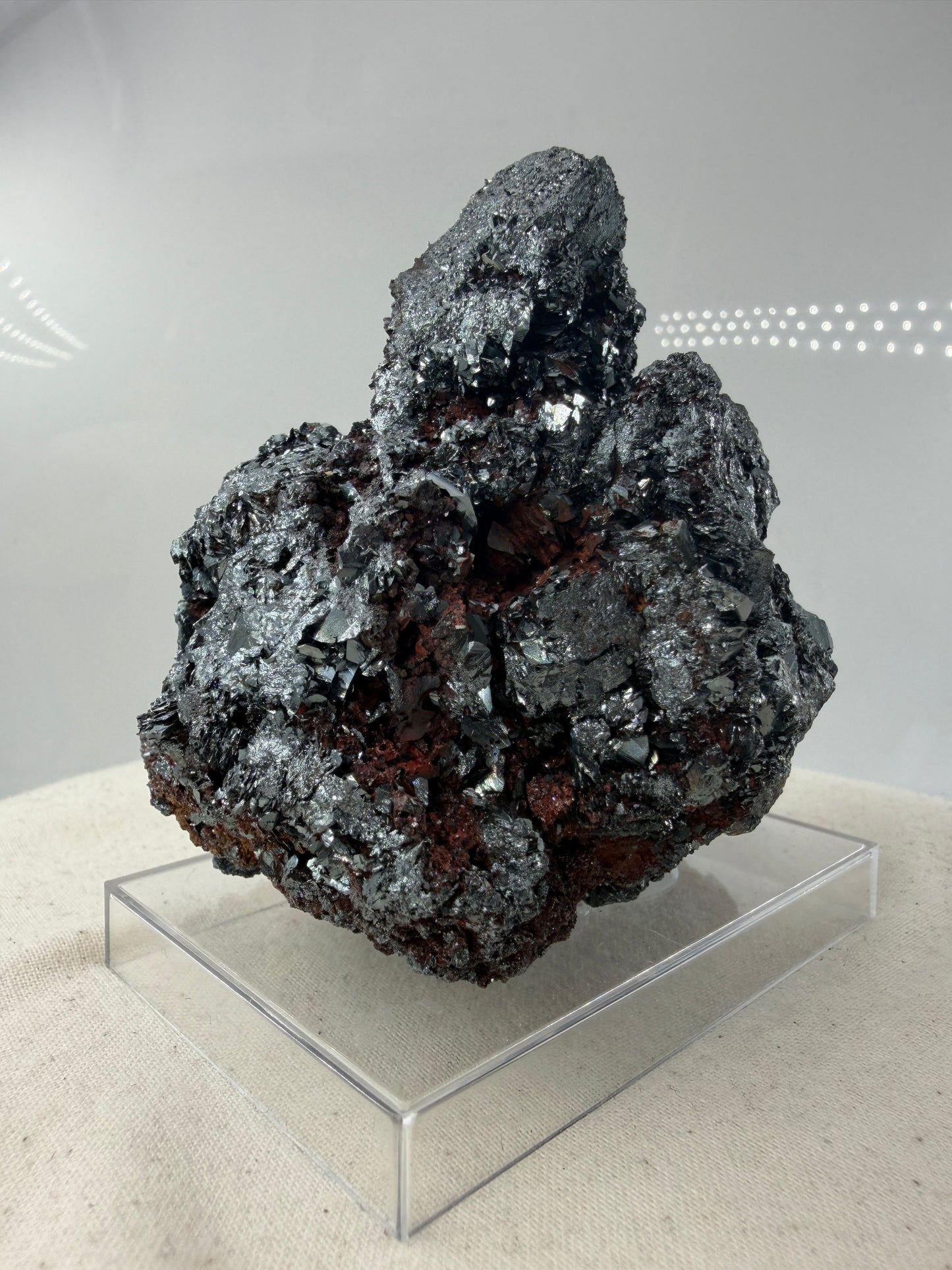 Hämatit-Specimen aus Elba, Italien, mit hochglänzenden, metallischen Mineralkristallen und charakteristischer linsenförmiger Struktur.