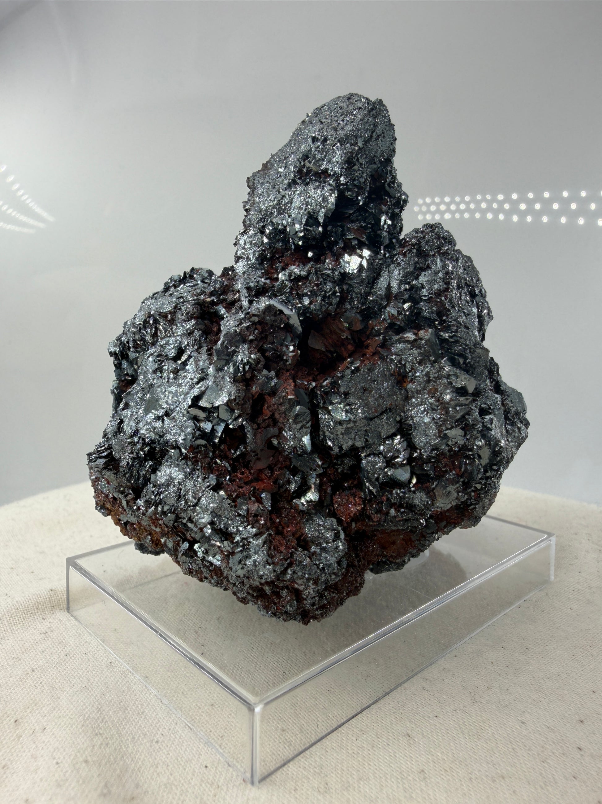 Hämatit-Specimen aus Elba, Italien, mit hochglänzenden, metallischen Mineralkristallen und charakteristischer linsenförmiger Struktur.