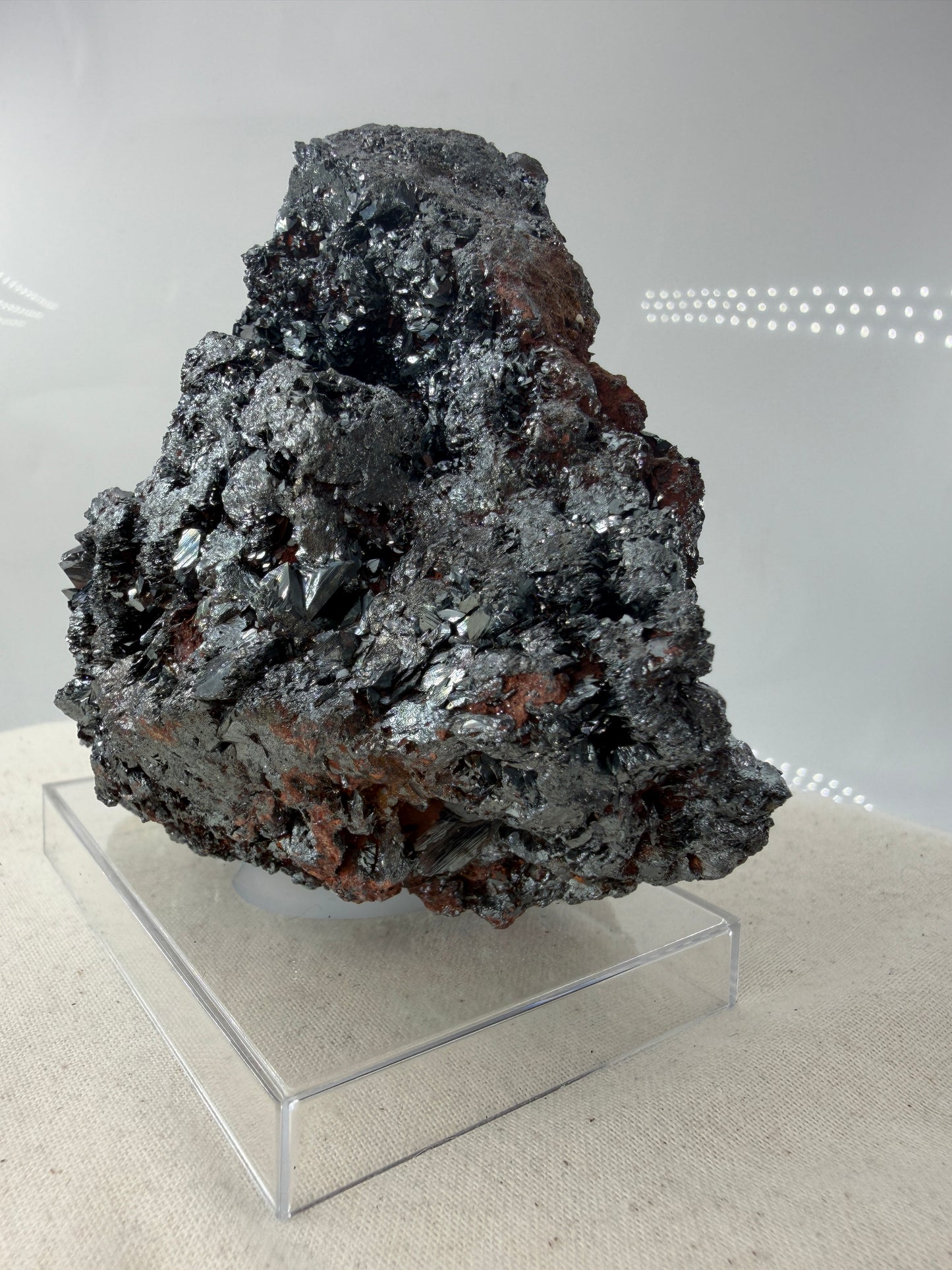 Hämatit-Specimen aus Elba, Italien, mit hochglänzenden, metallischen Mineralkristallen und charakteristischer linsenförmiger Struktur.