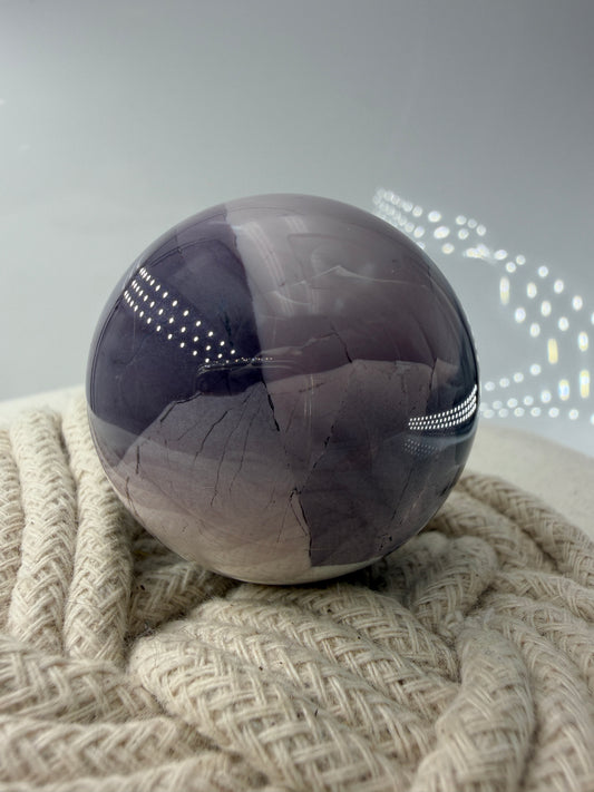 Polierte Edelsteinkugel aus Hyazinth-Jaspis mit markanten lila und cremefarbenen Mustern.