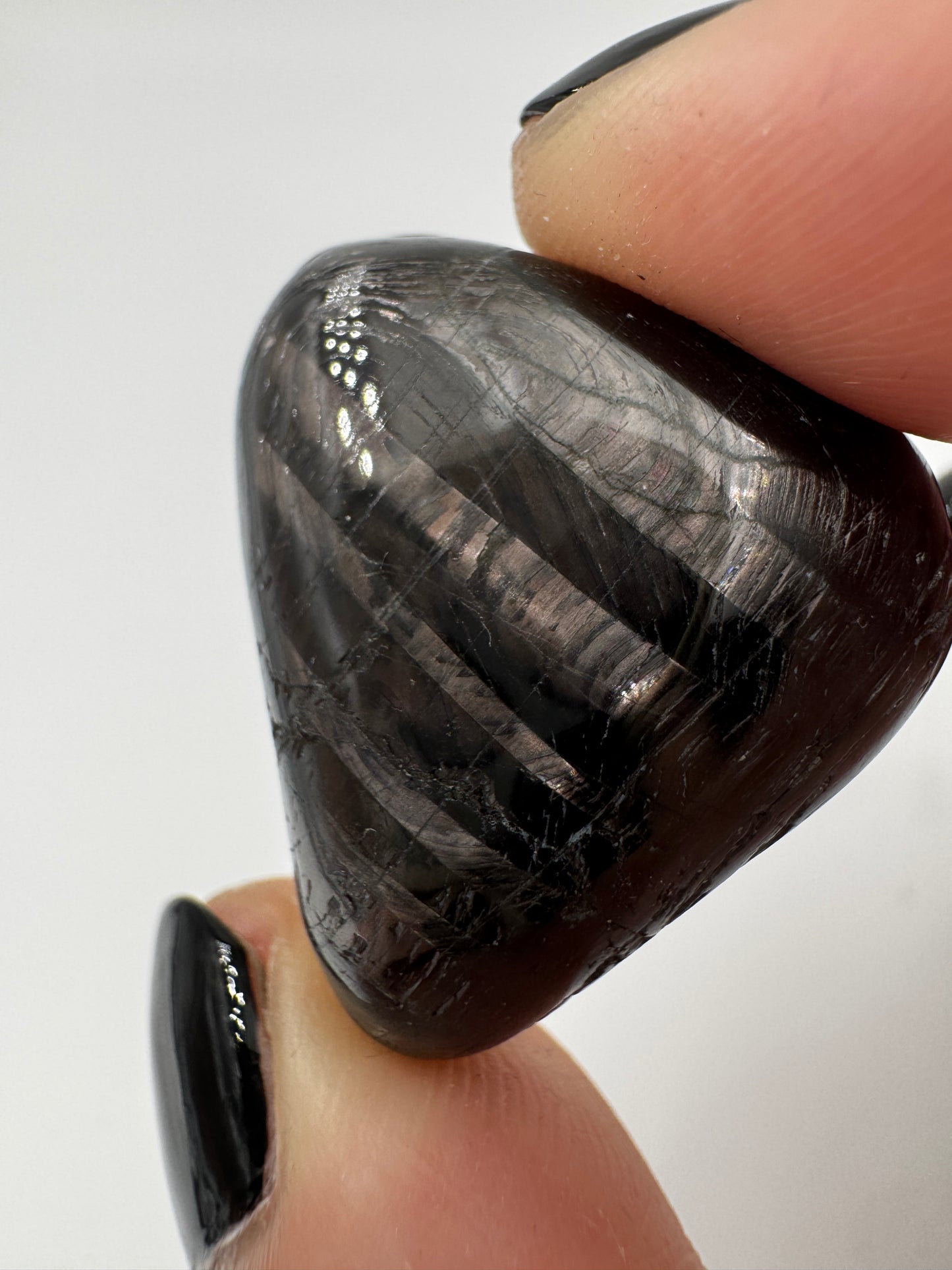 Polierte Hypersthen-Trommelsteine mit submetallischem Schimmer.