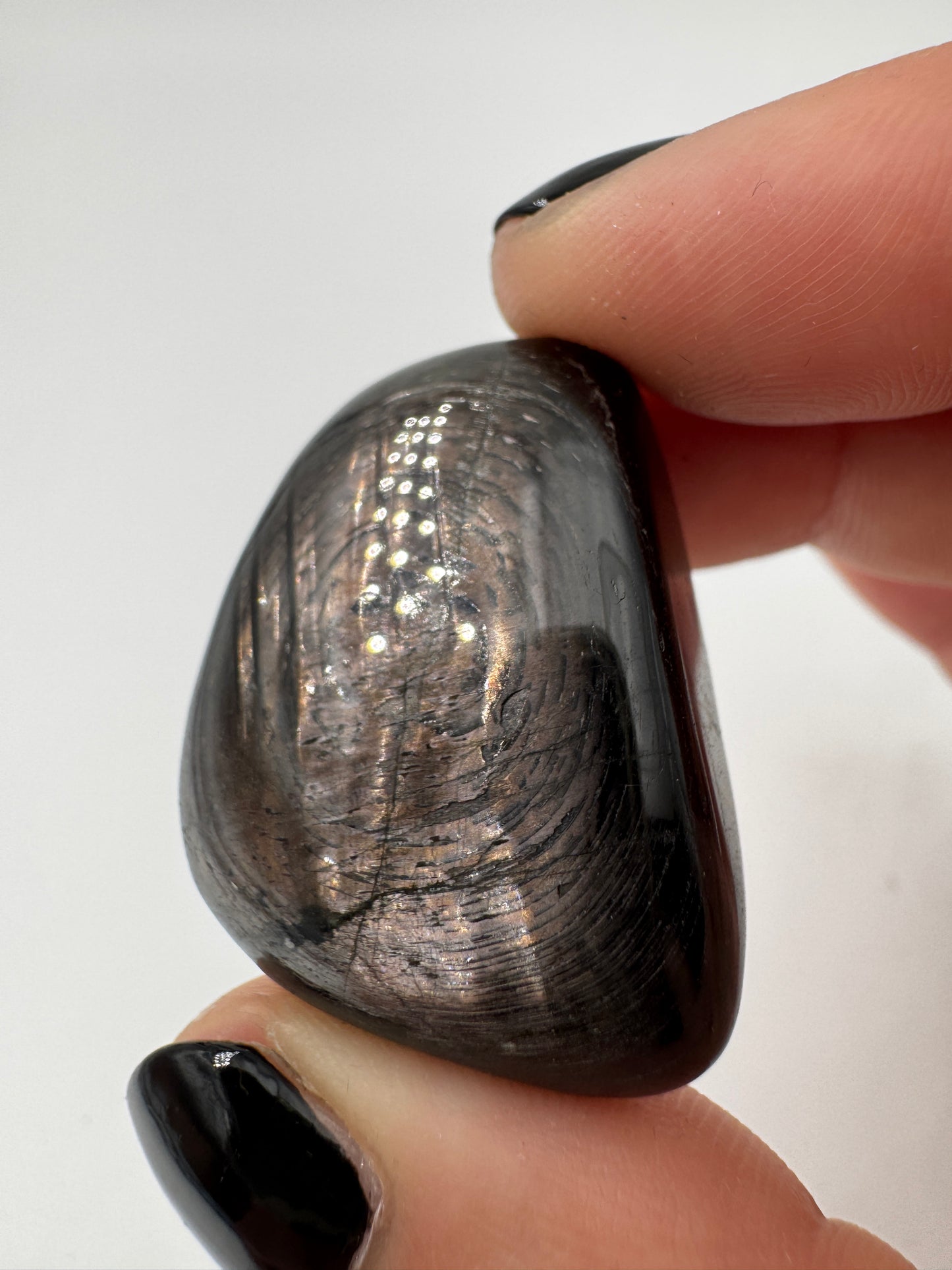 Polierte Hypersthen-Trommelsteine mit submetallischem Schimmer.