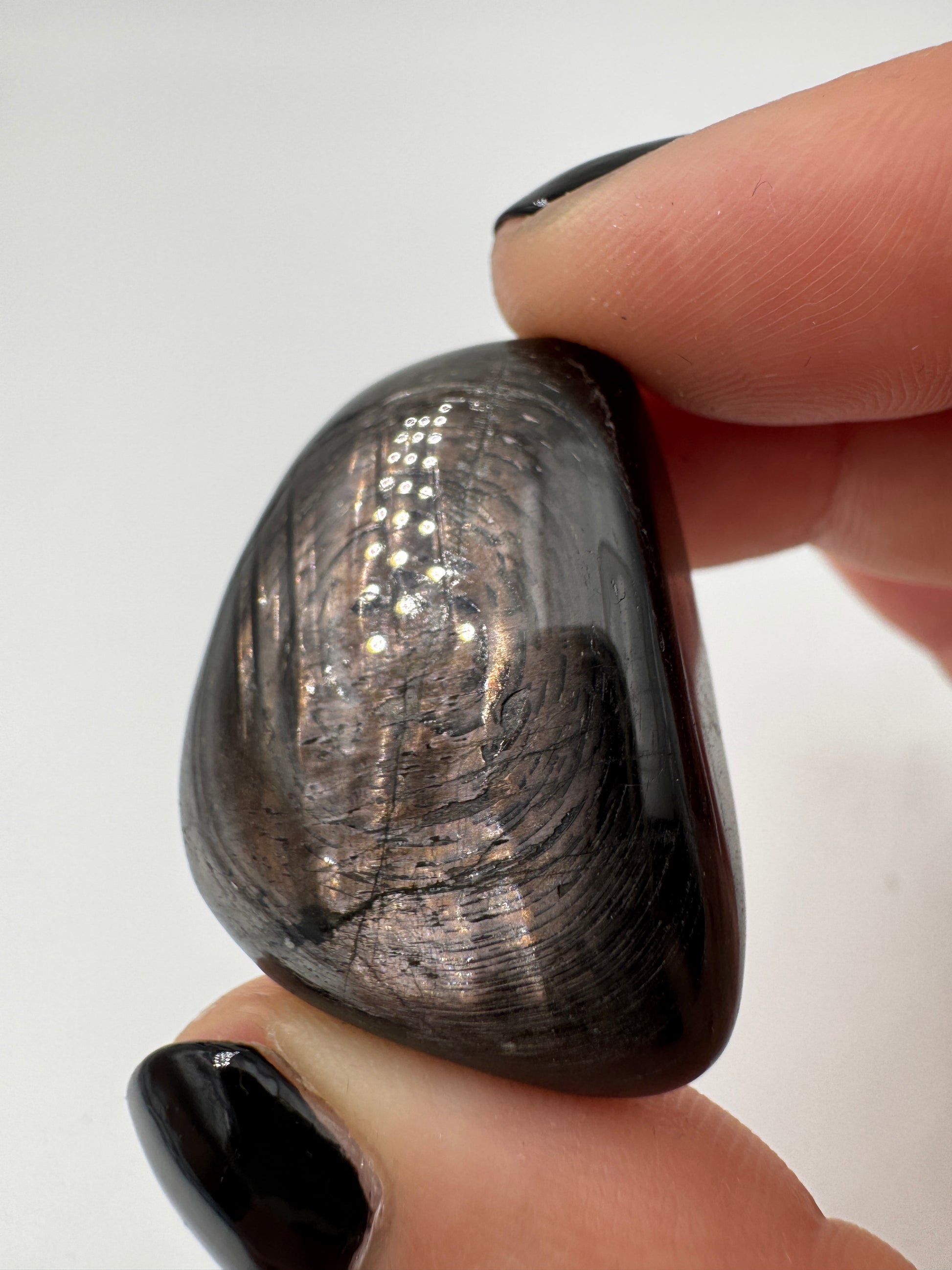 Polierte Hypersthen-Trommelsteine mit submetallischem Schimmer.