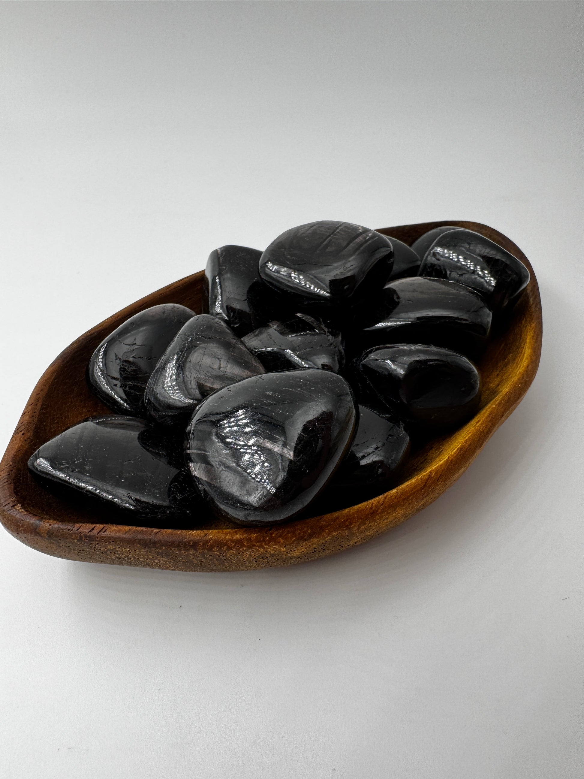 Polierte Hypersthen-Trommelsteine mit submetallischem Schimmer.