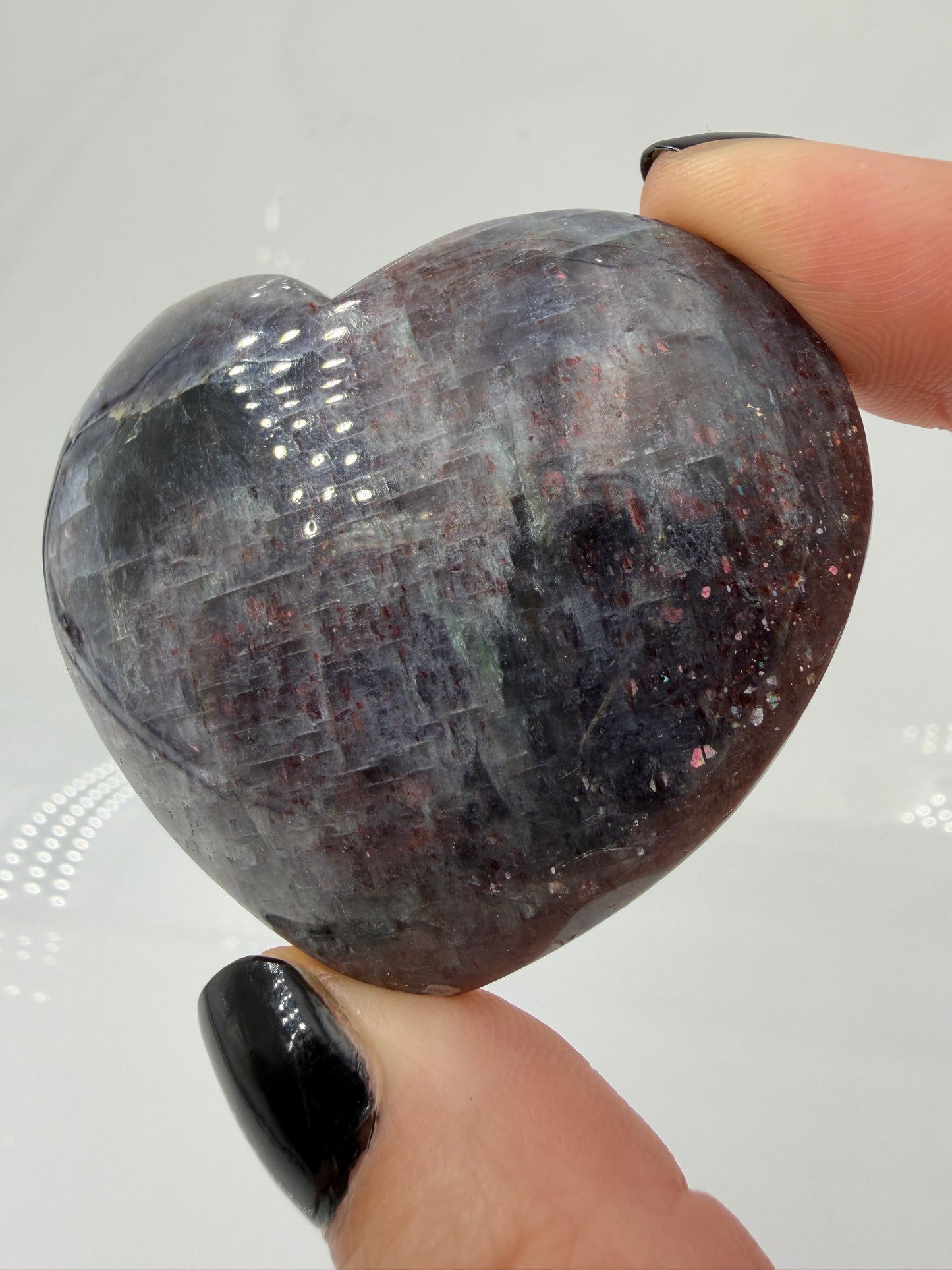 Ein Herz aus dunkelblauem Iolith, mit Sonnenstein. Die glatte Oberfläche zeigt je nach Lichteinfall einen metallischen Glanz und die charakteristischen Farbumschläge der beiden Mineralvarianten.
