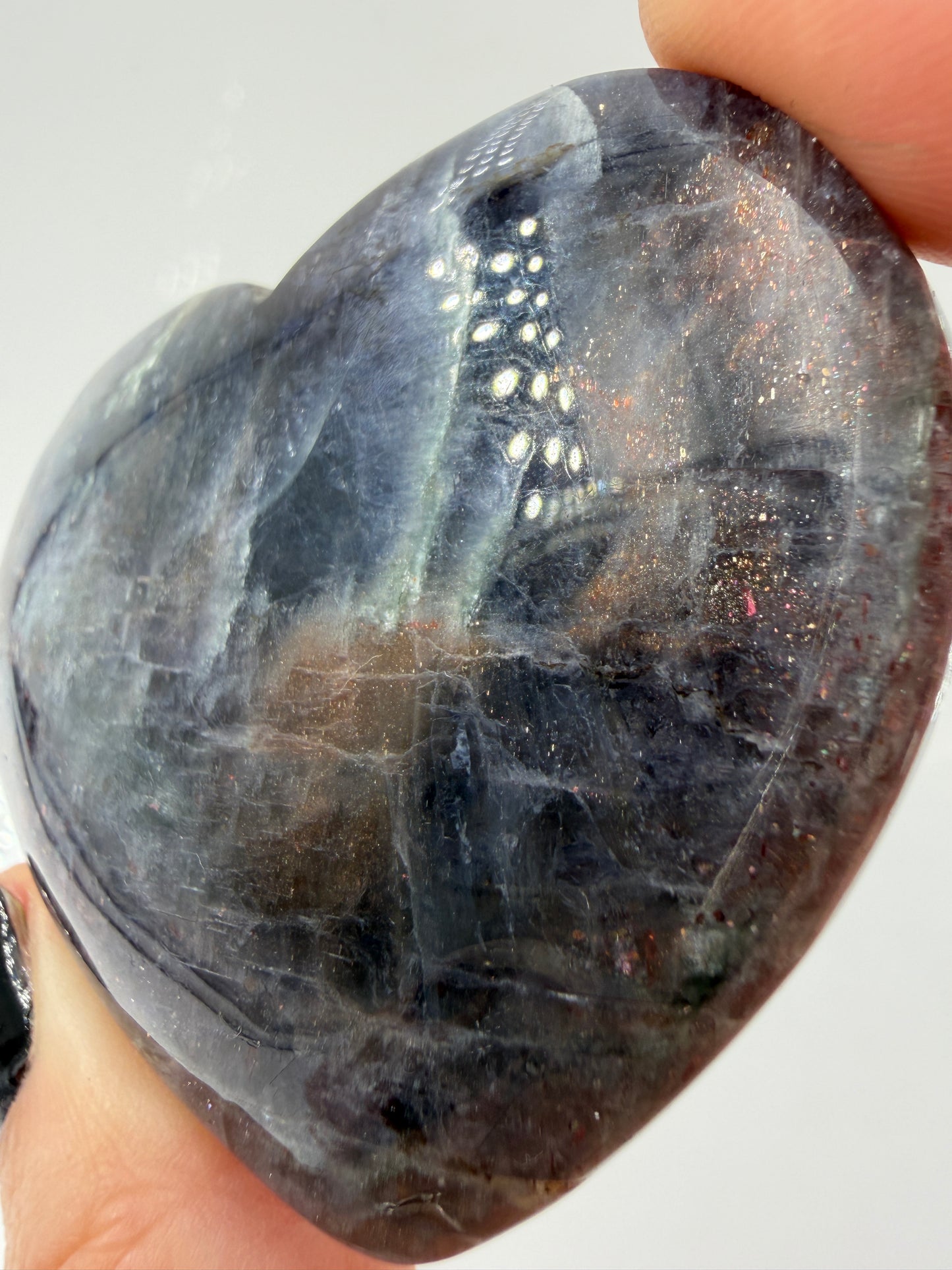 Ein Herz aus dunkelblauem Iolith, mit Sonnenstein. Die glatte Oberfläche zeigt je nach Lichteinfall einen metallischen Glanz und die charakteristischen Farbumschläge der beiden Mineralvarianten.