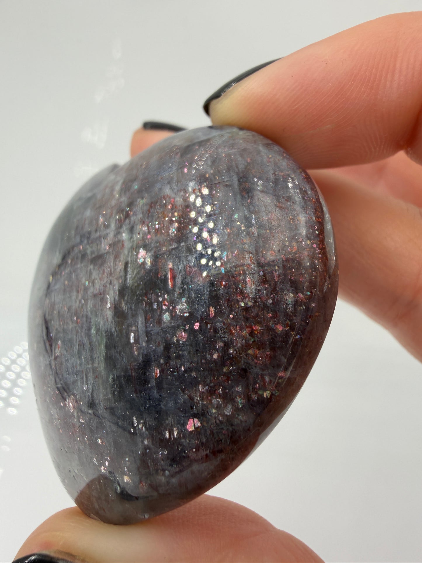 Ein Herz aus dunkelblauem Iolith, mit Sonnenstein. Die glatte Oberfläche zeigt je nach Lichteinfall einen metallischen Glanz und die charakteristischen Farbumschläge der beiden Mineralvarianten.