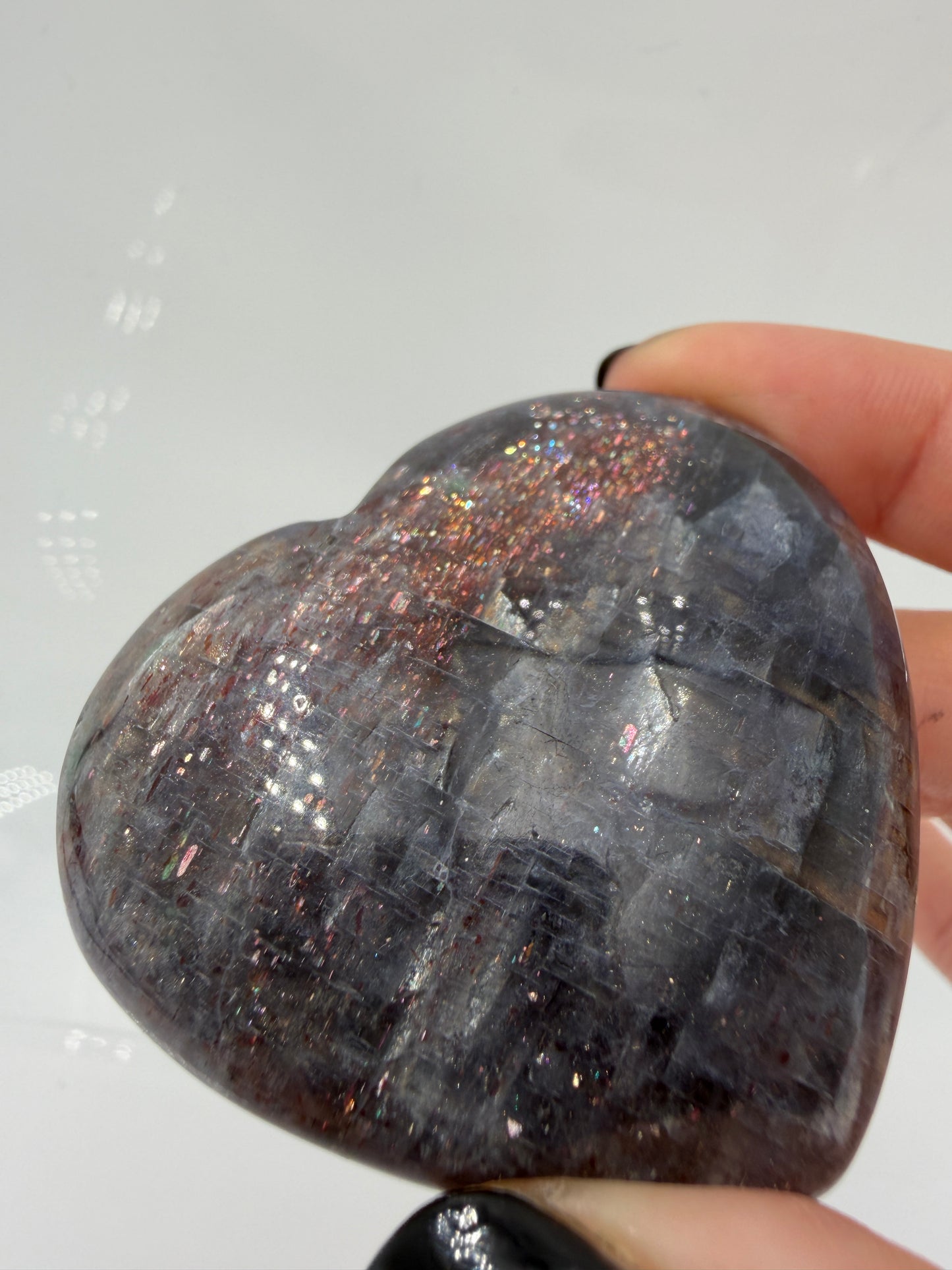 Ein Herz aus dunkelblauem Iolith, mit Sonnenstein. Die glatte Oberfläche zeigt je nach Lichteinfall einen metallischen Glanz und die charakteristischen Farbumschläge der beiden Mineralvarianten.