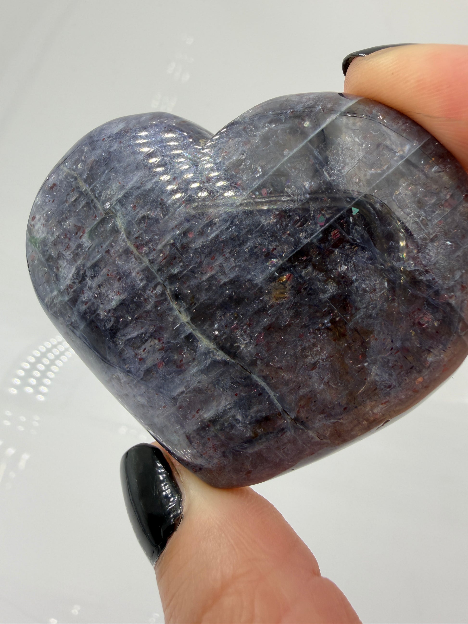 Ein Herz aus dunkelblauem Iolith, mit Sonnenstein. Die glatte Oberfläche zeigt je nach Lichteinfall einen metallischen Glanz und die charakteristischen Farbumschläge der beiden Mineralvarianten.