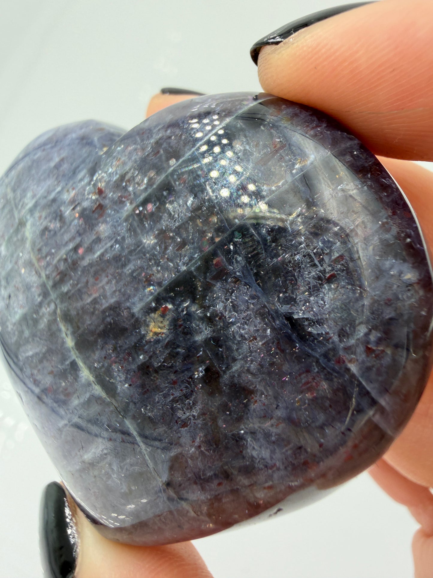 Ein Herz aus dunkelblauem Iolith, mit Sonnenstein. Die glatte Oberfläche zeigt je nach Lichteinfall einen metallischen Glanz und die charakteristischen Farbumschläge der beiden Mineralvarianten.