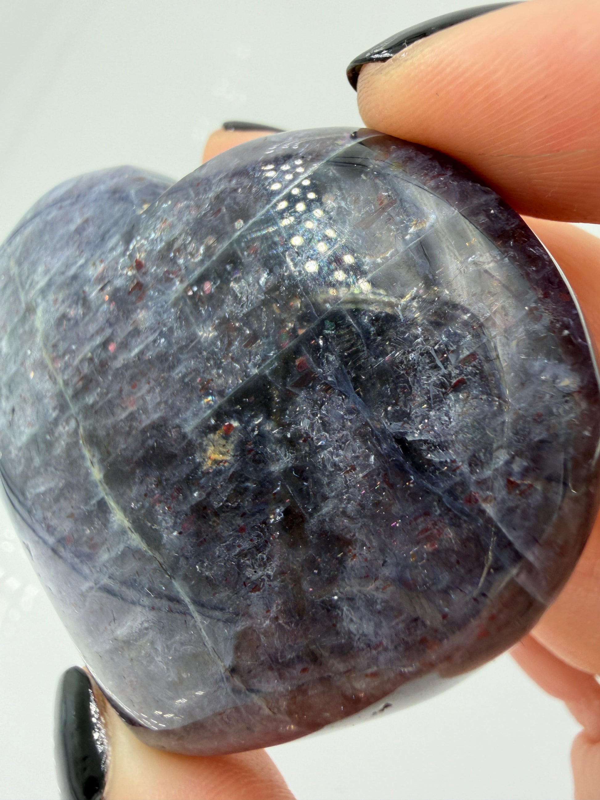 Ein Herz aus dunkelblauem Iolith, mit Sonnenstein. Die glatte Oberfläche zeigt je nach Lichteinfall einen metallischen Glanz und die charakteristischen Farbumschläge der beiden Mineralvarianten.