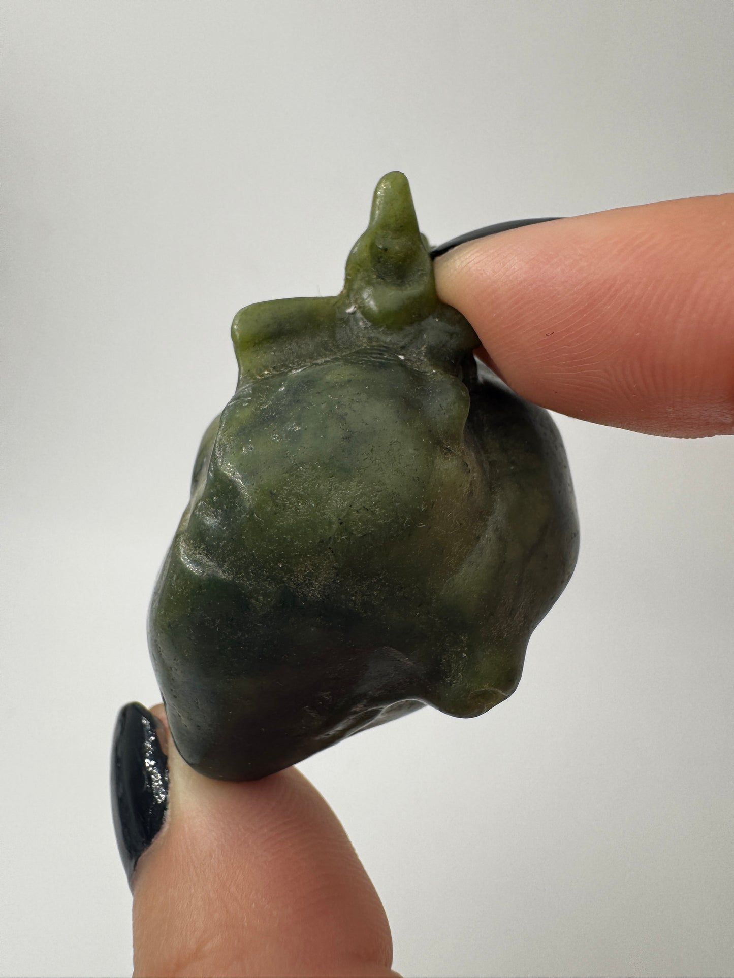 Ein fein skulpturiertes anatomisches Herz aus grüner Jade mit detailgetreuen Arterien und einer sanft schimmernden Oberfläche.