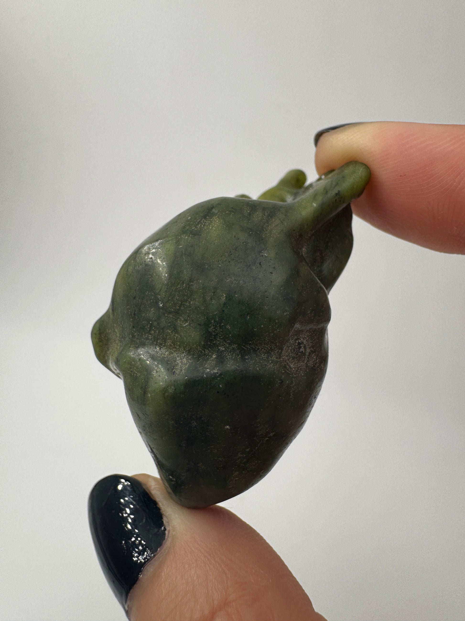 Ein fein skulpturiertes anatomisches Herz aus grüner Jade mit detailgetreuen Arterien und einer sanft schimmernden Oberfläche.