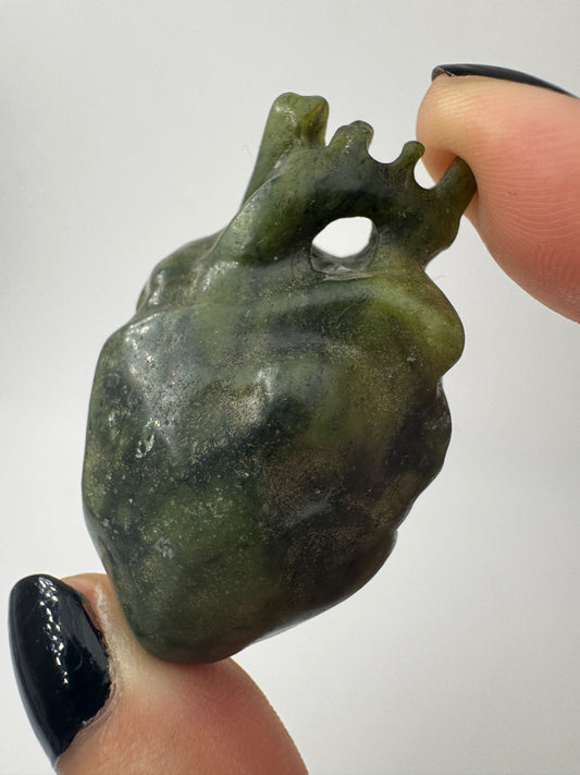 Ein fein skulpturiertes anatomisches Herz aus grüner Jade mit detailgetreuen Arterien und einer sanft schimmernden Oberfläche.