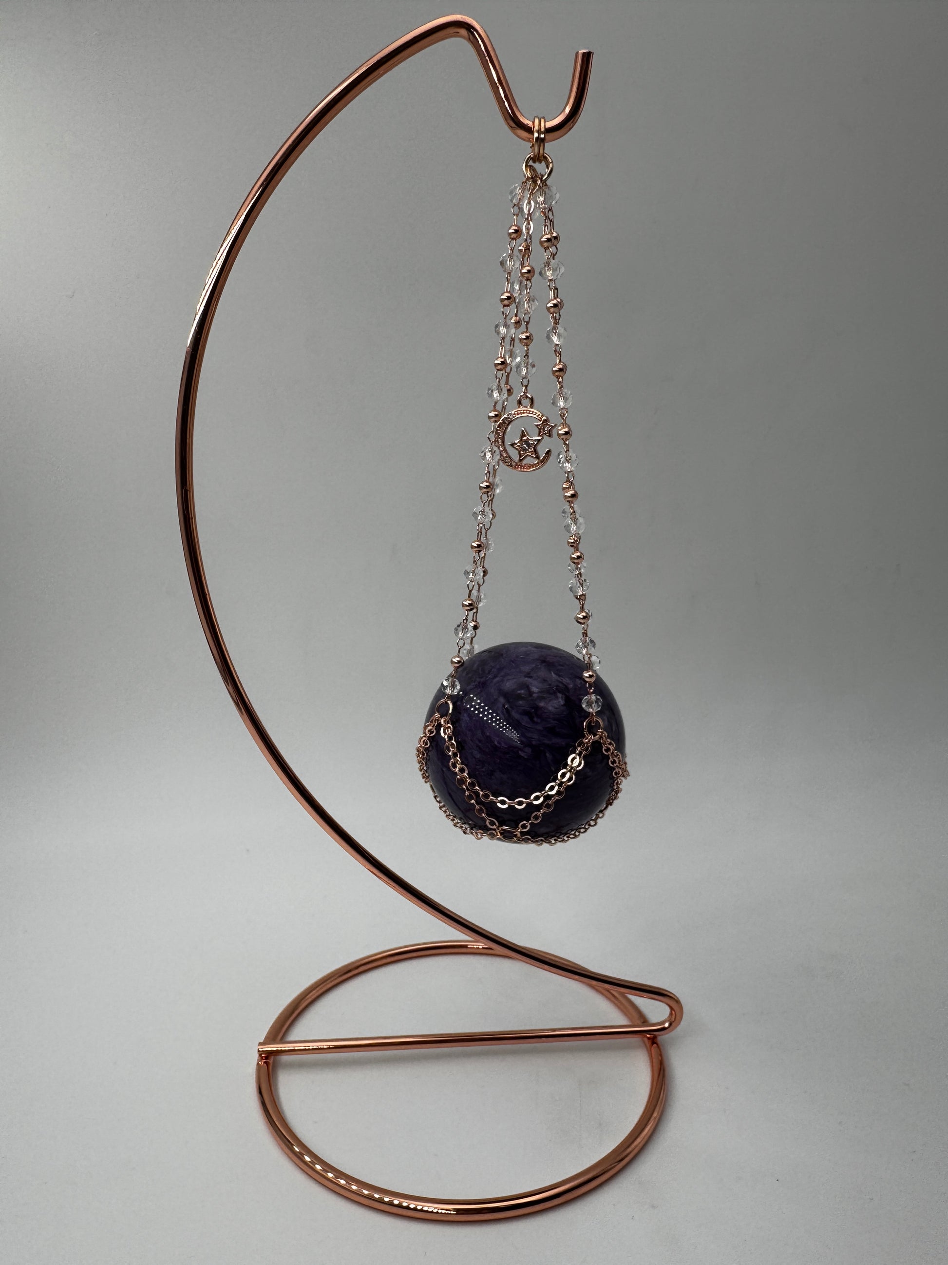 Roséfarbener Metallständer für Mineralkugeln, Höhe 23,5 cm, mit einer Beispielkugel von 4,7 cm Durchmesser.