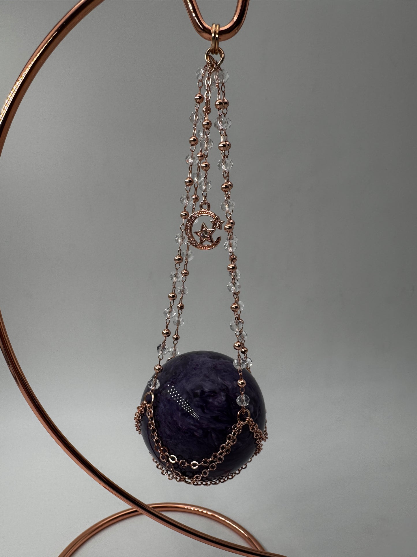 Roséfarbener Metallständer für Mineralkugeln, Höhe 23,5 cm, mit einer Beispielkugel von 4,7 cm Durchmesser.