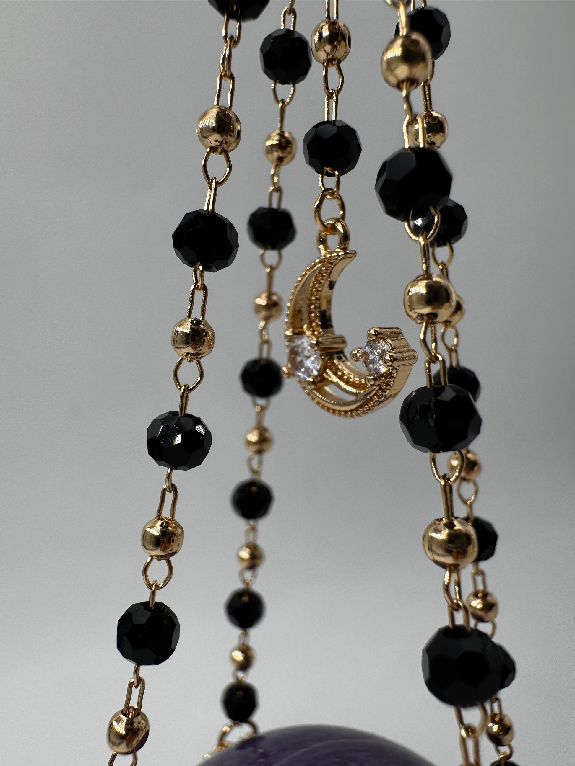 Kugelhalter in Schwarz-Gold aus Metall, Höhe 23,5 cm, mit einer Beispielkugel von 4,7 cm Durchmesser.