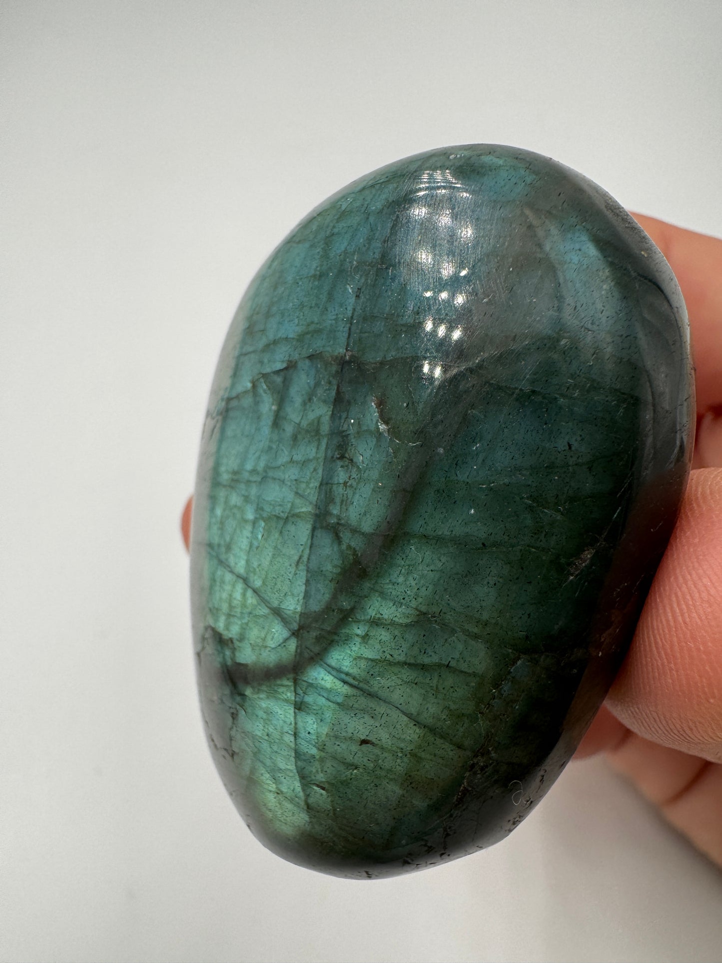 Labradorit Handstein, ca. 5–7 cm – Feldspatvarietät mit irisierendem Labradoreszenz-Effekt in Blau und Grün.