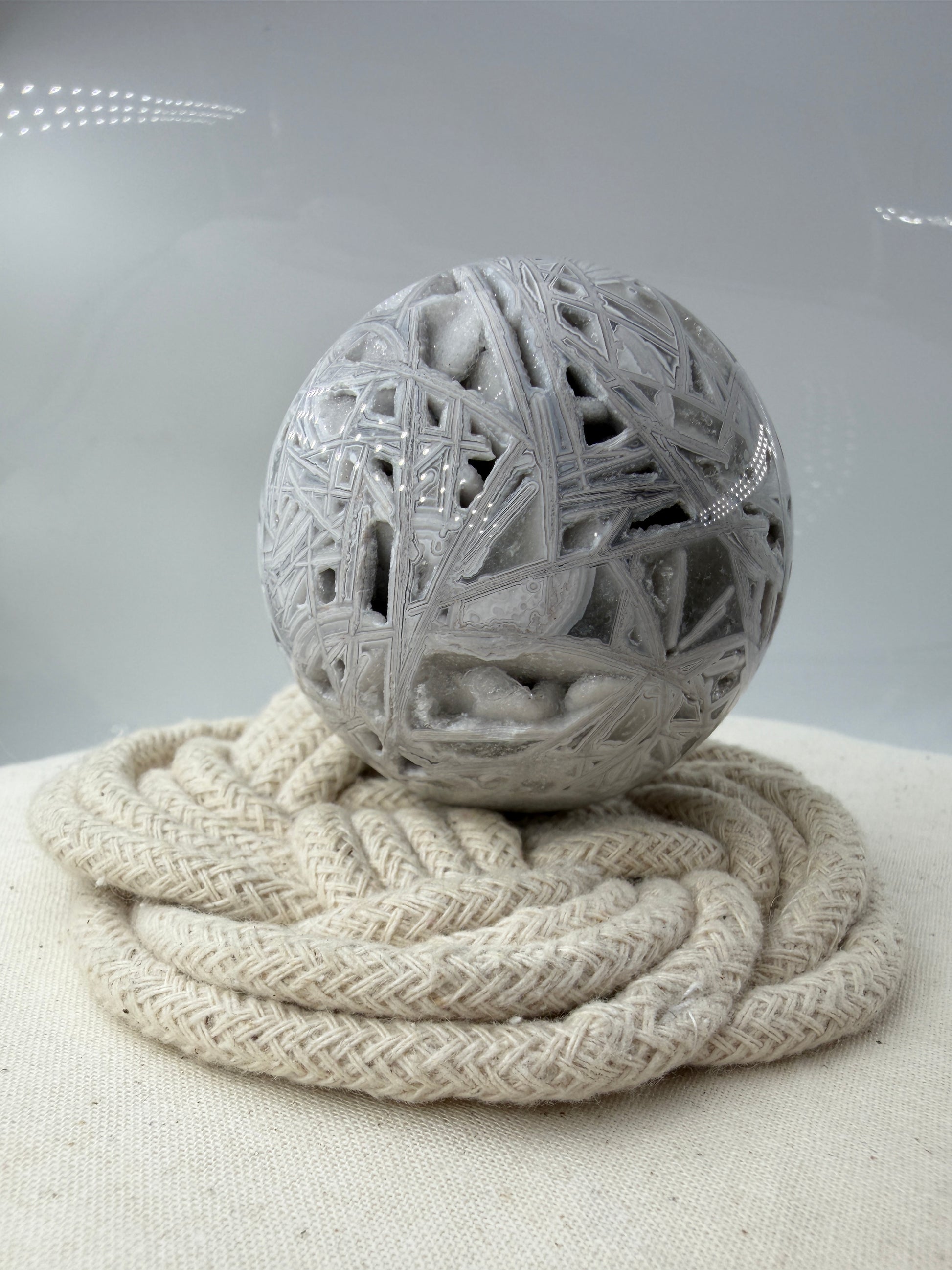 Handpolierte Lace Achat Kugel in Weiß und Grau mit natürlichen Drusen und charakteristischen Bänderungen, Ø 6,0 cm – edles Sammlerstück aus Quarz.