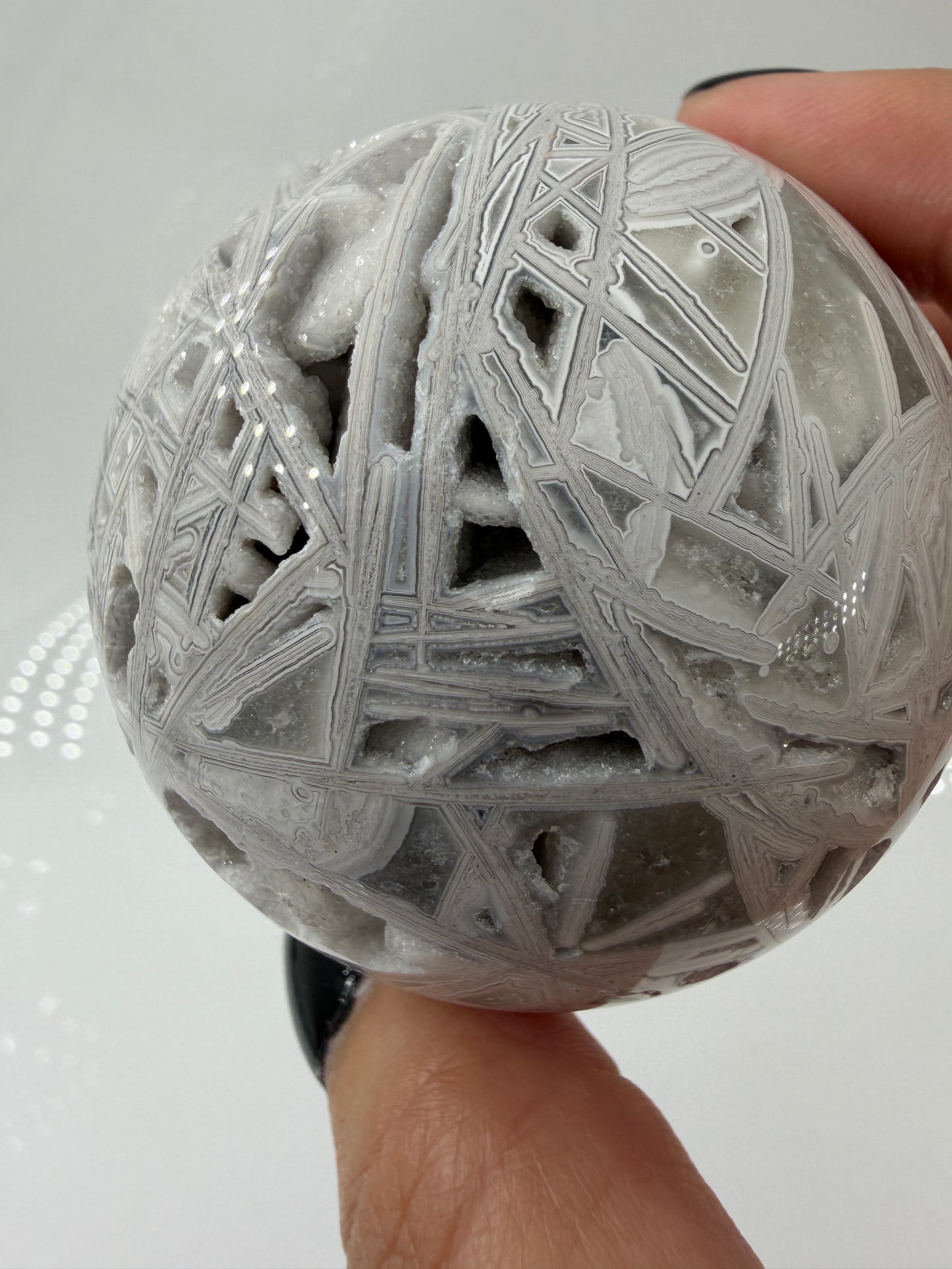 Handpolierte Lace Achat Kugel in Weiß und Grau mit natürlichen Drusen und charakteristischen Bänderungen, Ø 6,0 cm – edles Sammlerstück aus Quarz.
