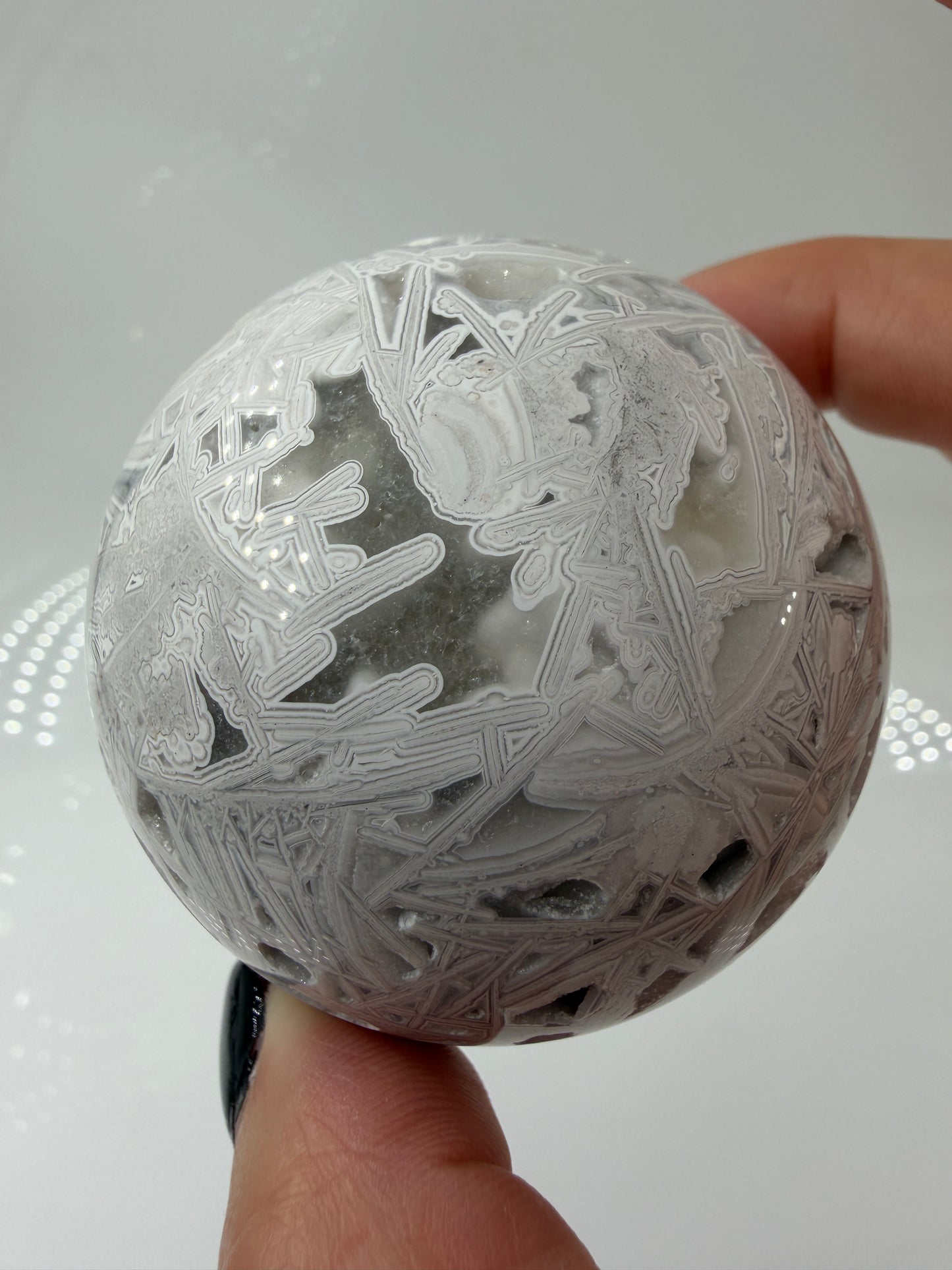 Handpolierte Lace Achat Kugel in Weiß und Grau mit natürlichen Drusen und charakteristischen Bänderungen, Ø 6,0 cm – edles Sammlerstück aus Quarz.