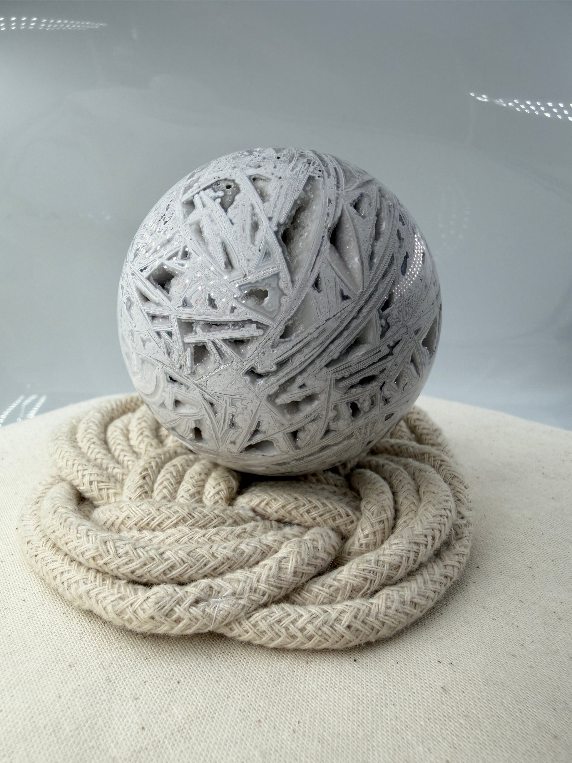 Handpolierte Lace Achat Kugel in Weiß und Grau mit natürlichen Drusen und charakteristischen Bänderungen, Ø 6,5 cm – edles Sammlerstück aus Quarz.
