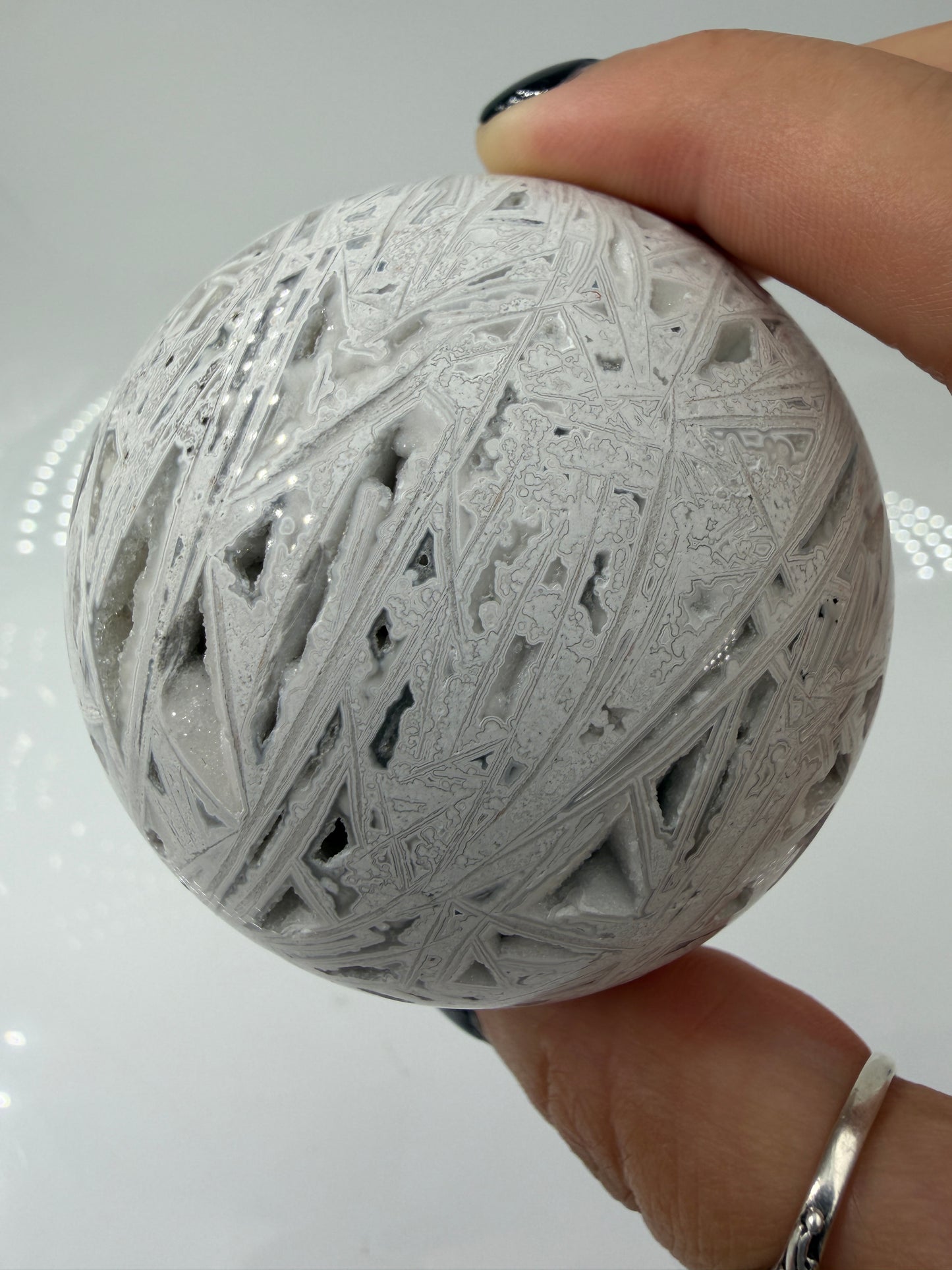 Handpolierte Lace Achat Kugel in Weiß und Grau mit natürlichen Drusen und charakteristischen Bänderungen, Ø 6,5 cm – edles Sammlerstück aus Quarz.