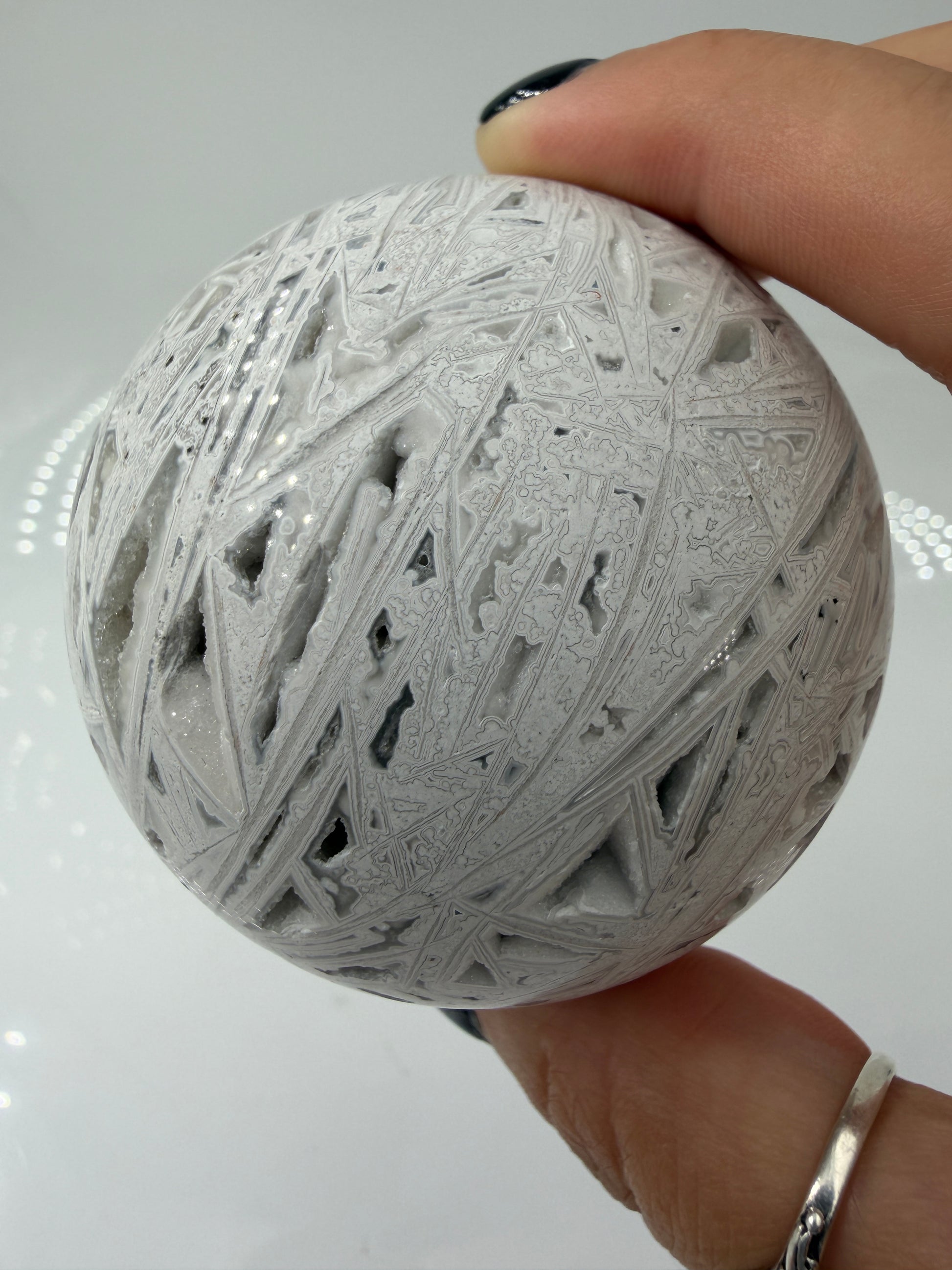 Handpolierte Lace Achat Kugel in Weiß und Grau mit natürlichen Drusen und charakteristischen Bänderungen, Ø 6,5 cm – edles Sammlerstück aus Quarz.