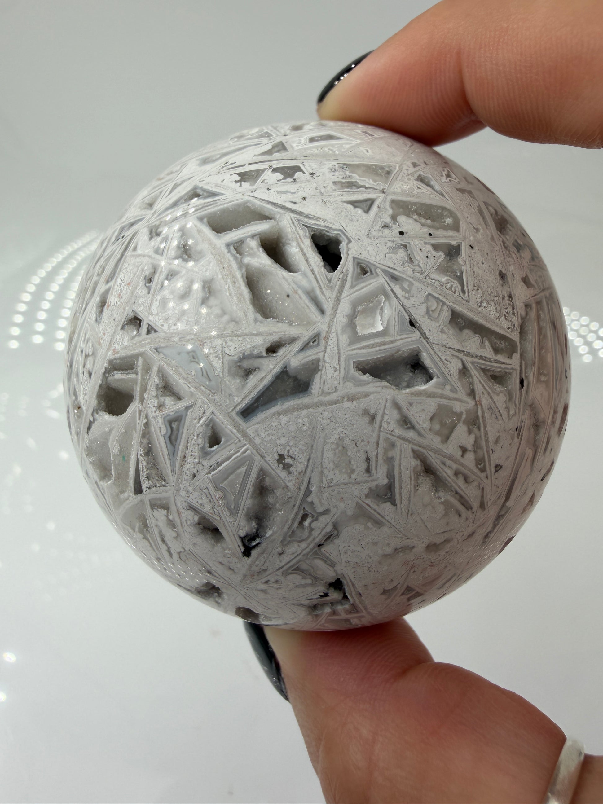 Handpolierte Lace Achat Kugel in Weiß und Grau mit natürlichen Drusen und charakteristischen Bänderungen, Ø 6,5 cm – edles Sammlerstück aus Quarz.