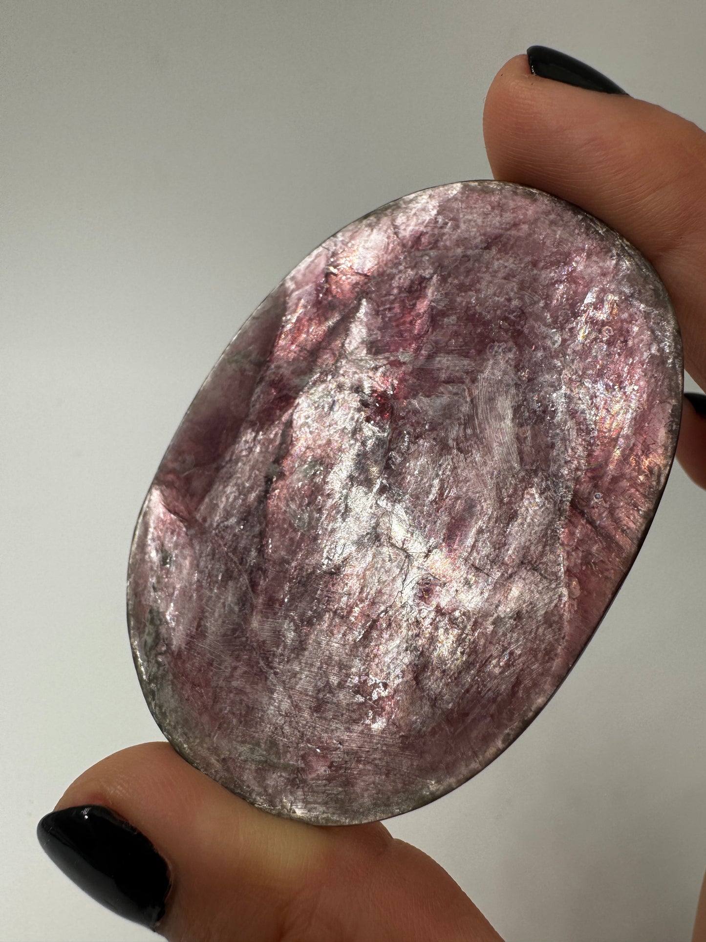 Ein glatt polierter, fliederfarbener Lepidolith-Handstein mit seidig glänzender Oberfläche und dezenten mineralischen Texturen.