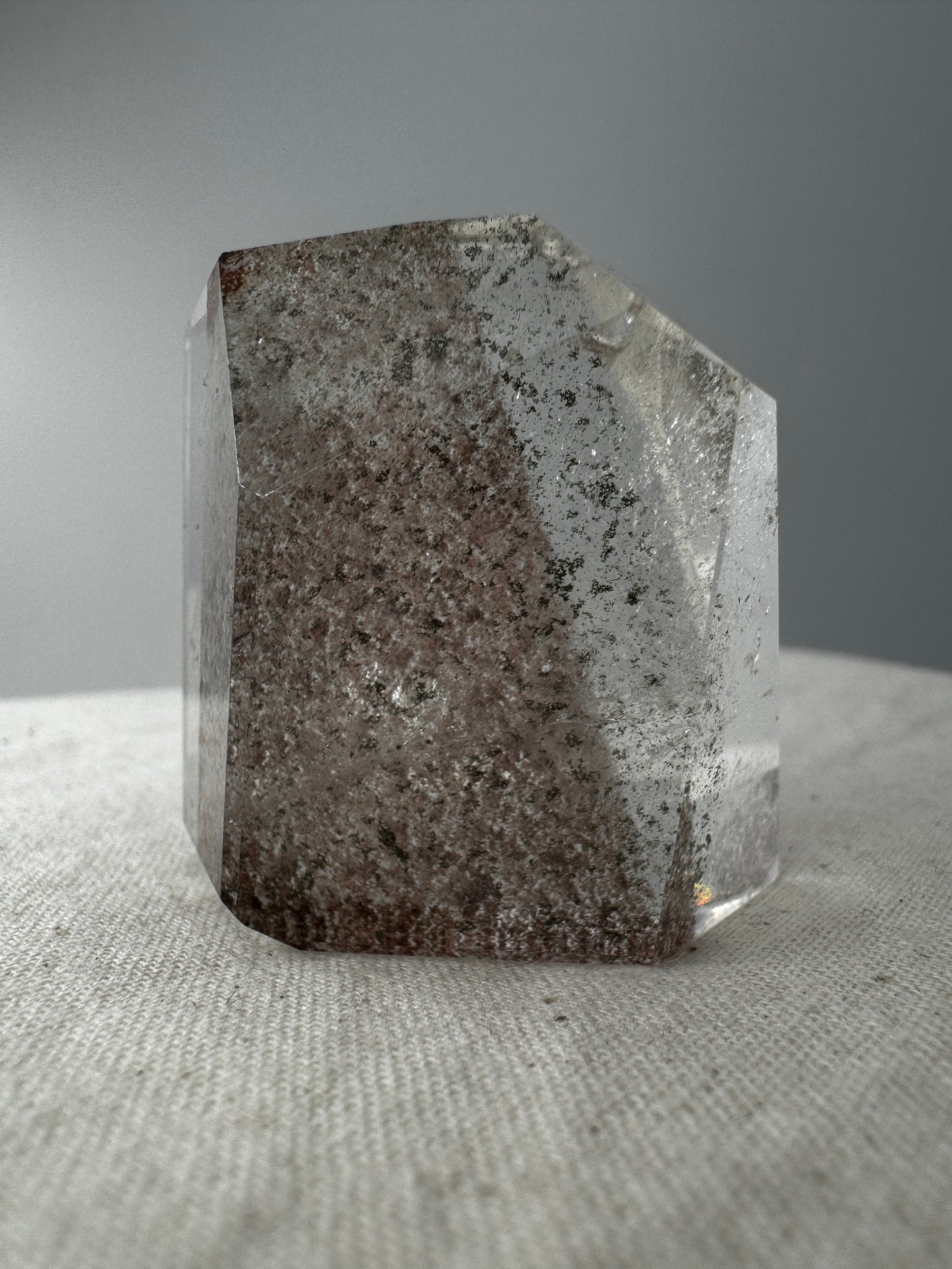 Lodolith Freiform GF19, mit dichten Chlorit- und Eisenoxid-Einschlüssen im klaren Quarz, freiform-geschliffen.