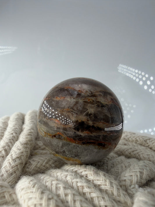 Polierte thousend layer Gartenquarz-Kugel mit einer  Vielzahl feiner, horizontaler Wachs-Phantome im Inneren.