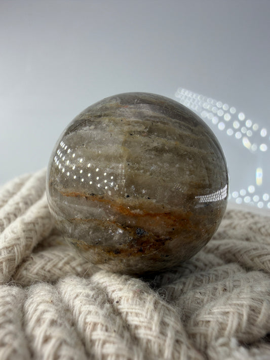 Polierte thousend layer Gartenquarz-Kugel mit einer  Vielzahl feiner, horizontaler Wachs-Phantome im Inneren.