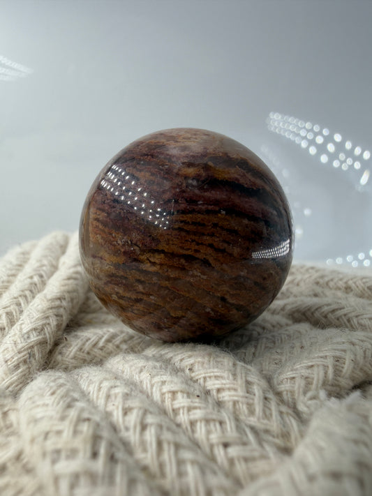 Polierte Lodolith-Kugel mit deutlich erkennbaren, schichtweisen Phantomeinschlüssen in klarem Quarz.