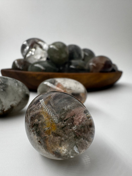 Mehrere hochglanzpolierte Lodolith-Trommelsteine zeigen in ihrem Inneren farbenfrohe, moosähnliche Mineraleinschlüsse, die wie konservierte Unterwasserlandschaften erscheinen.