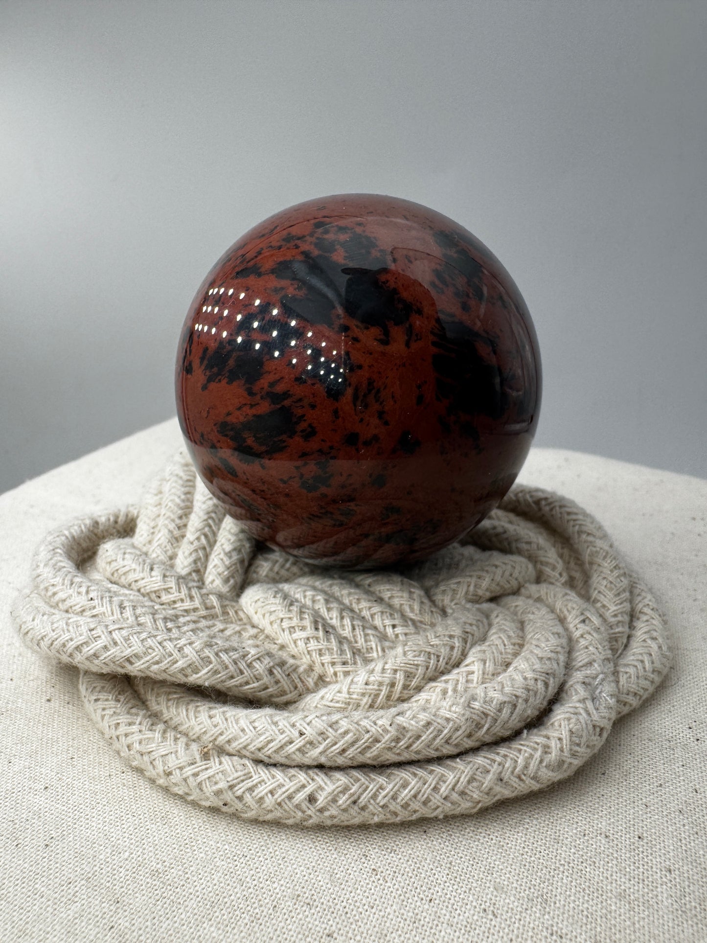 Polierte Kugel aus Mahagoni Obsidian mit rotbraun-schwarzer Maserung, Durchmesser 5,6 cm.