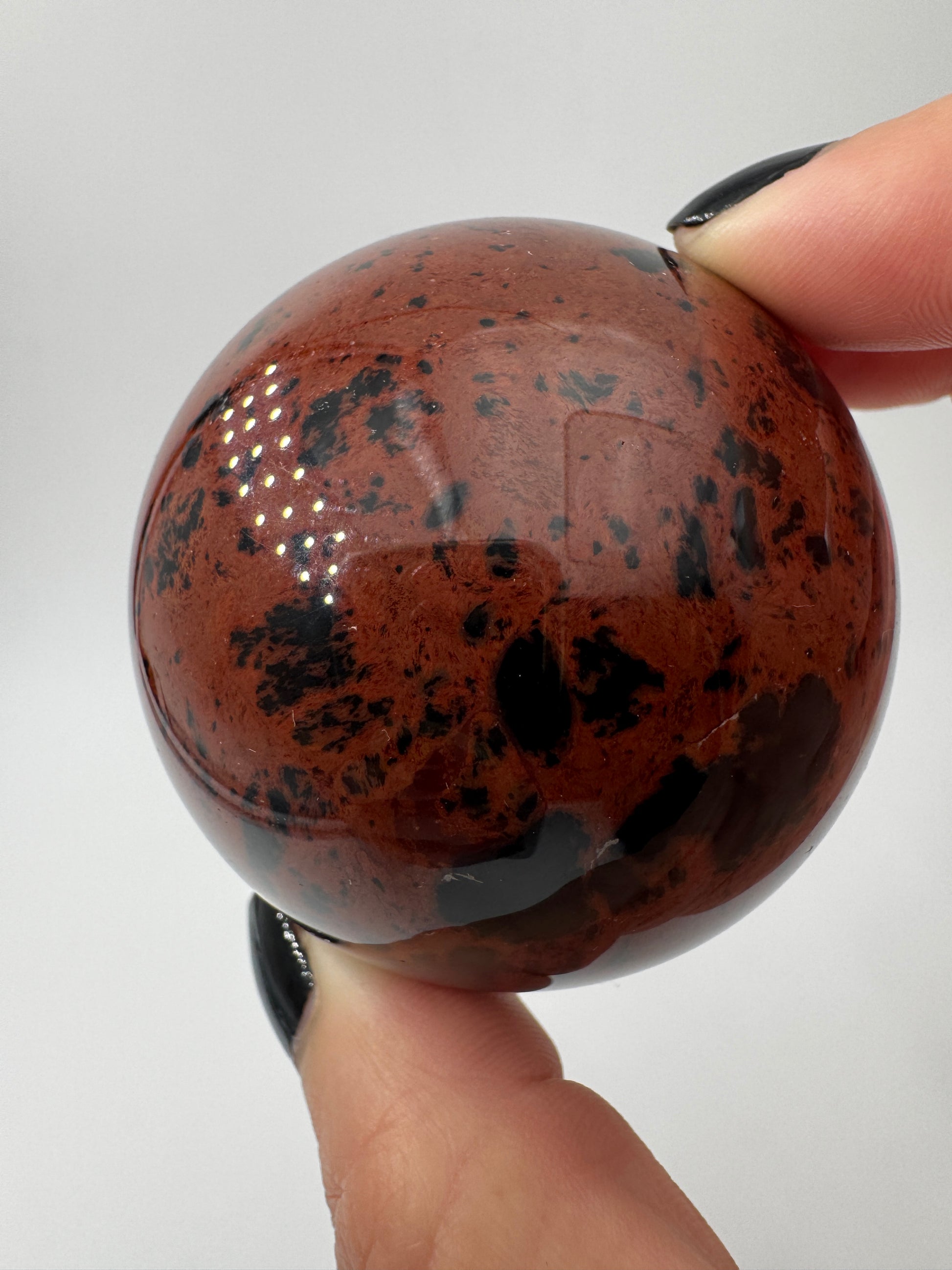 Polierte Kugel aus Mahagoni Obsidian mit rotbraun-schwarzer Maserung, Durchmesser 5,6 cm.
