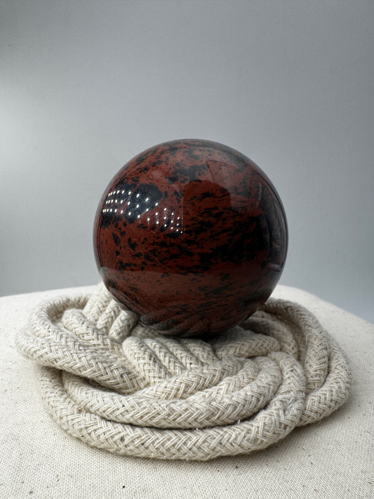 Polierte Kugel aus Mahagoni Obsidian mit rotbraun-schwarzer Maserung, Durchmesser 6 cm.