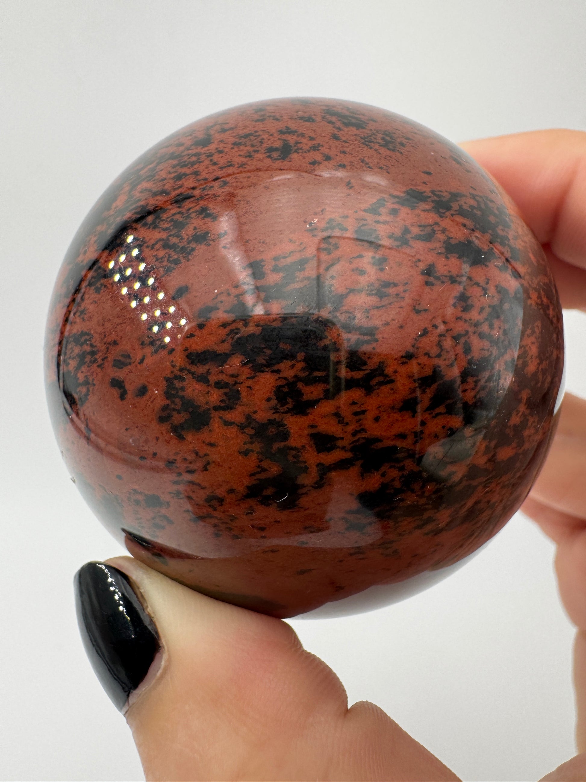 Polierte Kugel aus Mahagoni Obsidian mit rotbraun-schwarzer Maserung, Durchmesser 6 cm.
