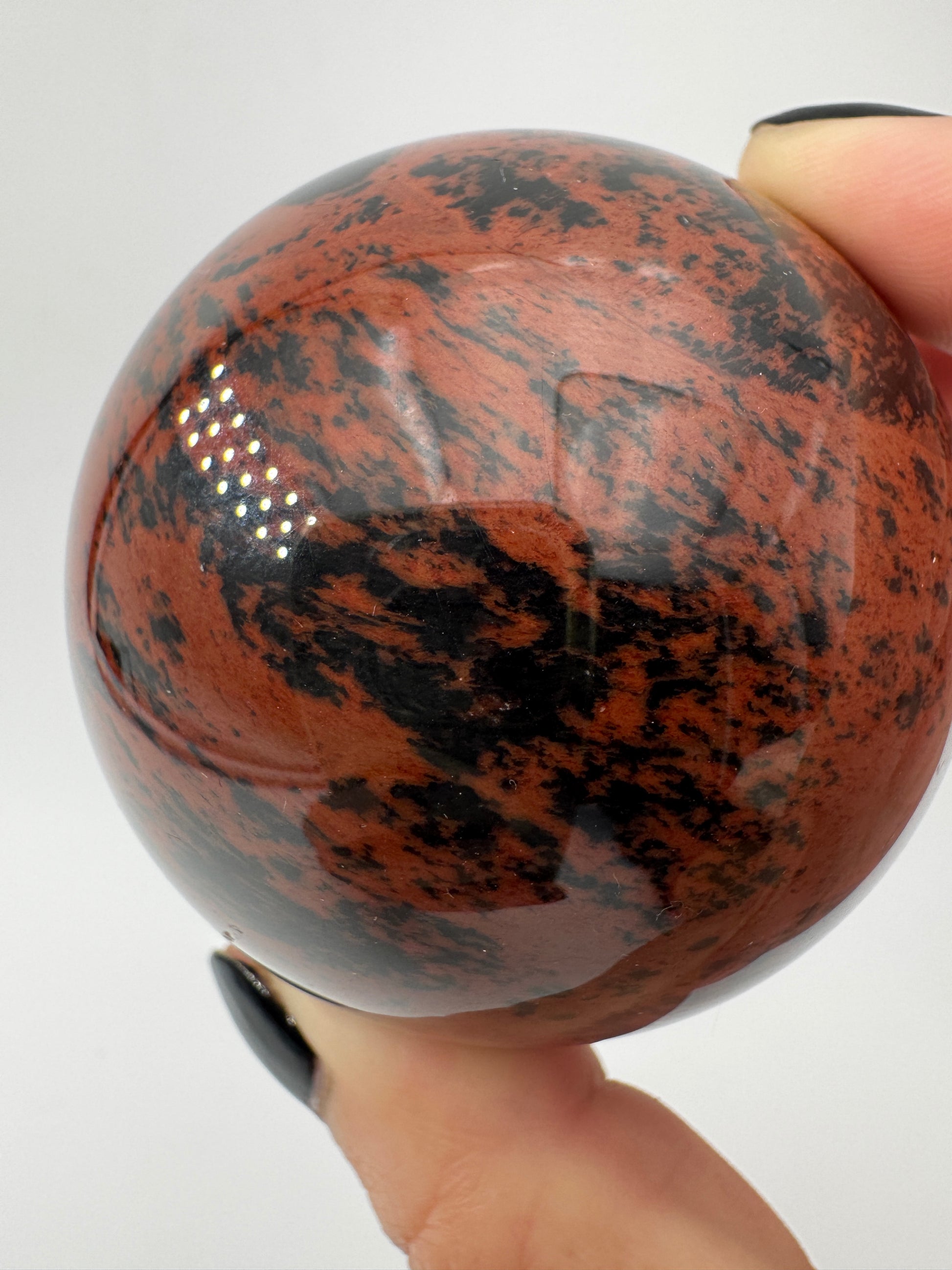 Polierte Kugel aus Mahagoni Obsidian mit rotbraun-schwarzer Maserung, Durchmesser 6 cm.
