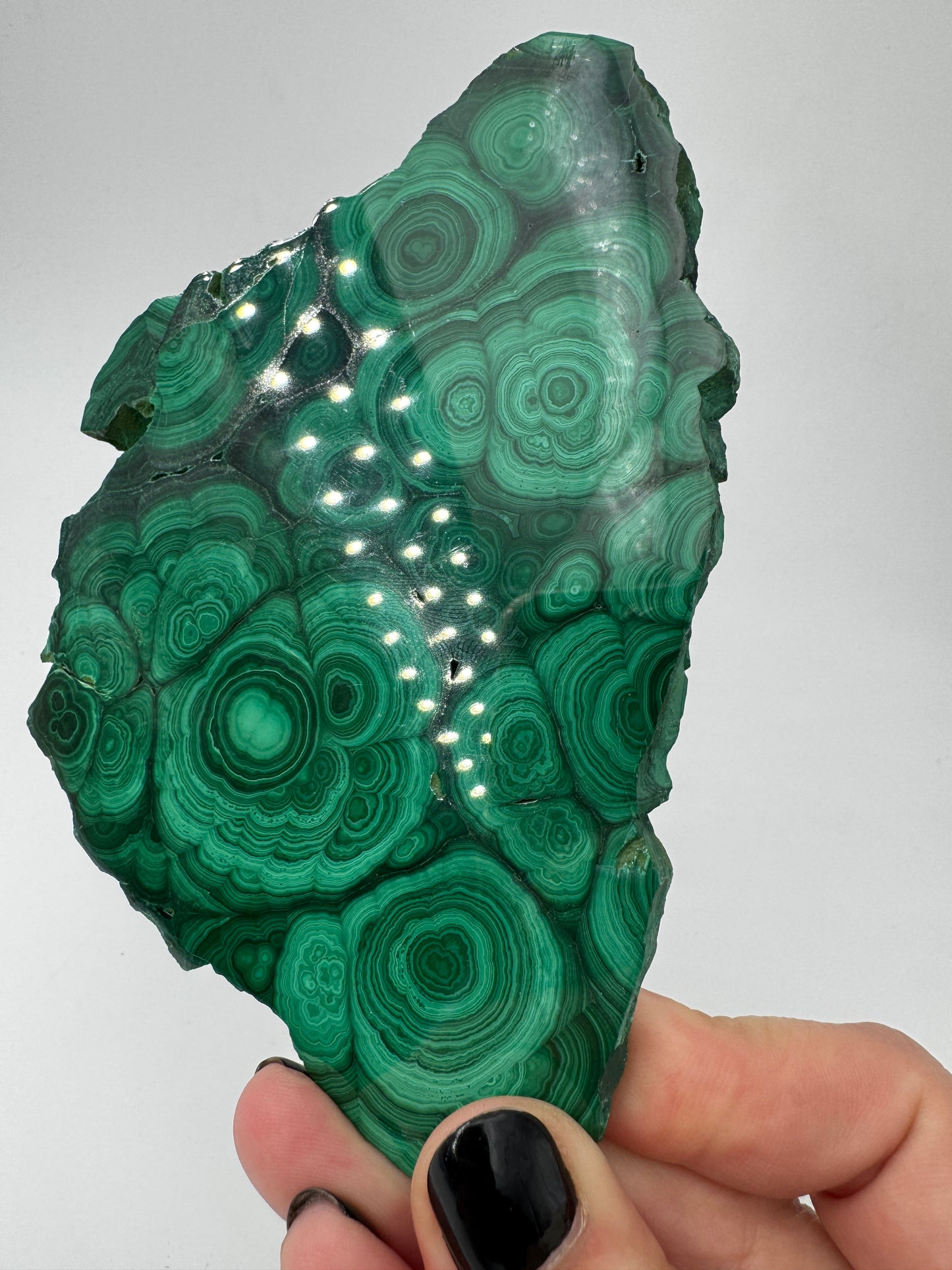 Beidseitig polierter Malachit-Anschliff mit konzentrischen grünen Bändern, 12 × 8 × 0,6 cm, natürliche Seiten.