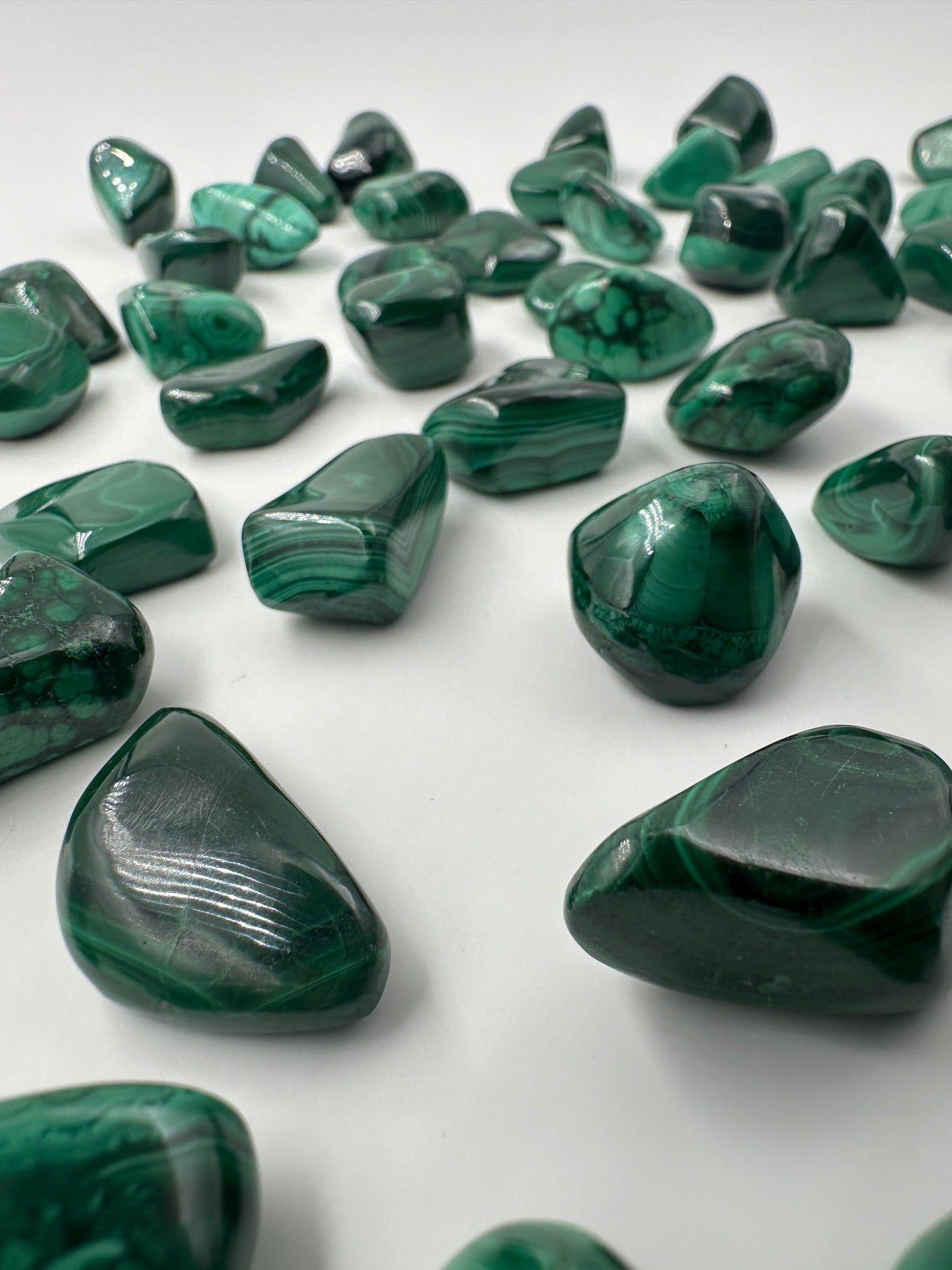 Malachit Trommelsteine, poliertes Kupferkarbonat-Mineral mit charakteristischer grüner Bänderung und konzentrischen Wachstumsmustern