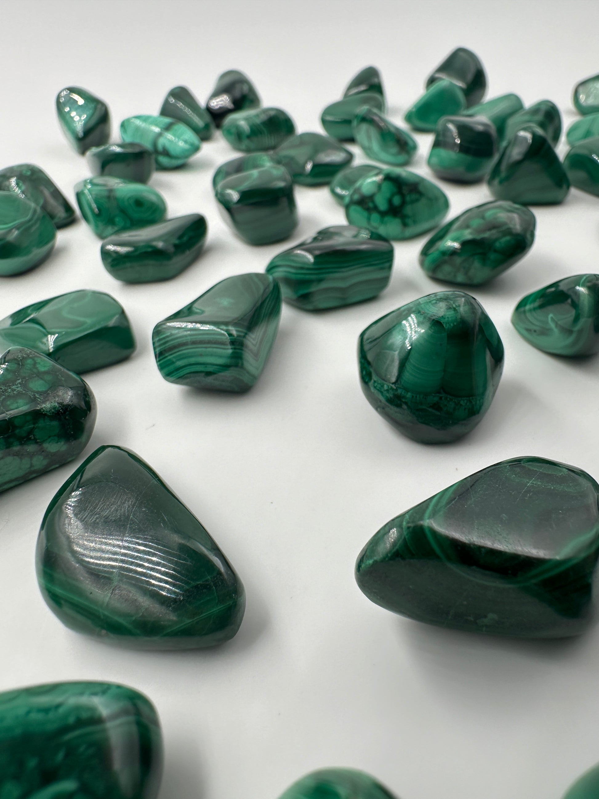 Malachit Trommelsteine, poliertes Kupferkarbonat-Mineral mit charakteristischer grüner Bänderung und konzentrischen Wachstumsmustern