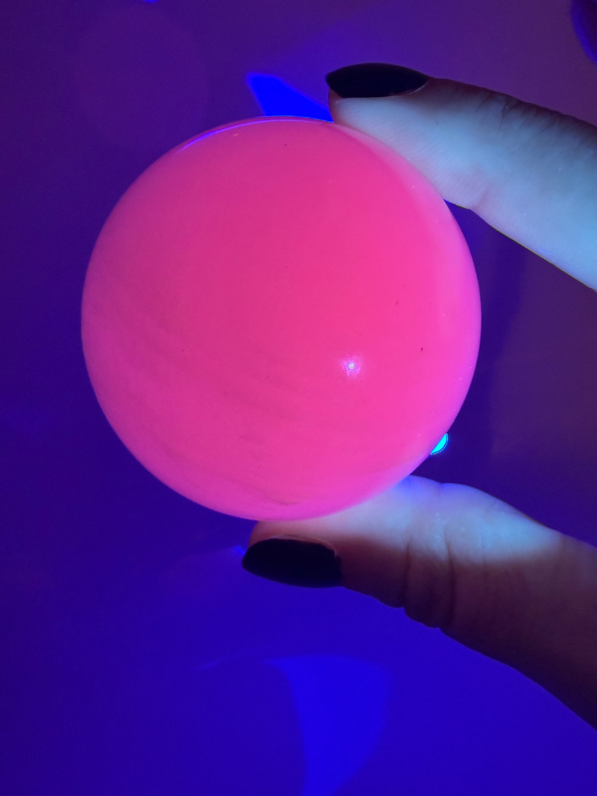 Handpolierte Mangano Calcit Kugel MK39 in zartrosa mit perlmuttartigem Glanz und UV-Fluoreszenz, Durchmesser 5,4 cm.