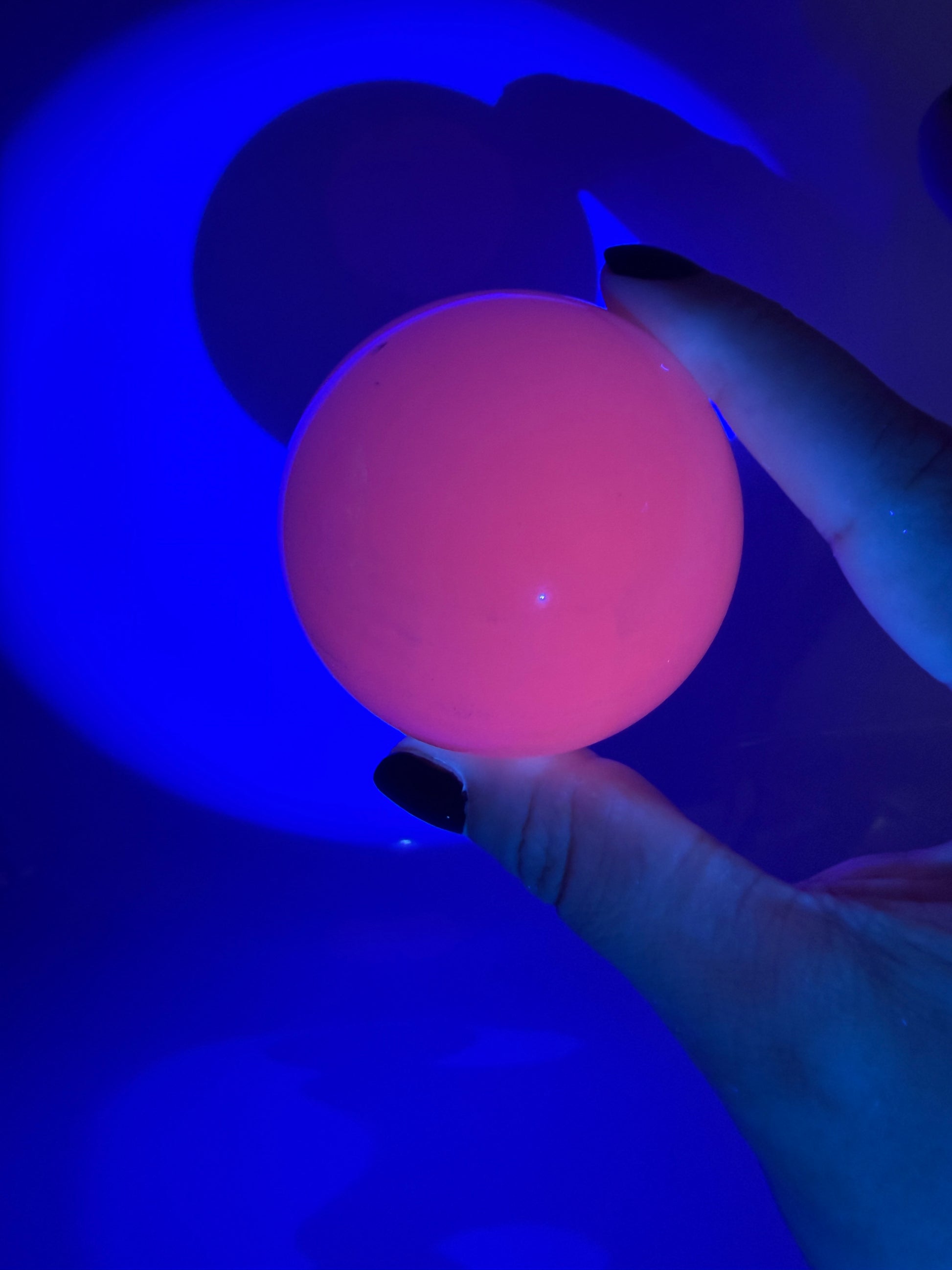 Handpolierte Mangano Calcit Kugel MK53 in zartrosa mit perlmuttartigem Glanz und UV-Fluoreszenz, Durchmesser 5,9 cm.