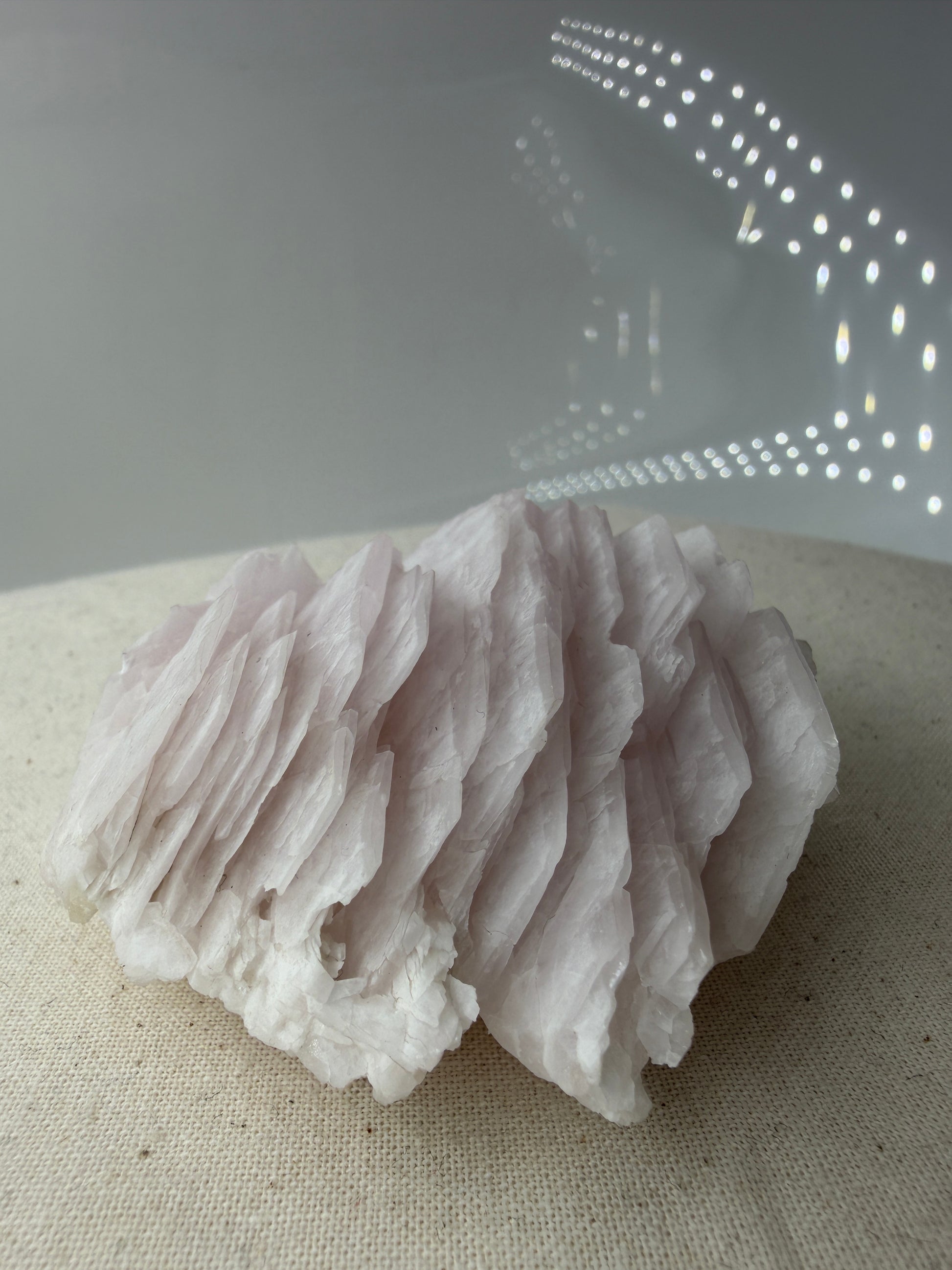 Naturbelassener Rohstein aus Mangano-Calcit in zartem Rosa mit sichtbaren Spaltflächen.