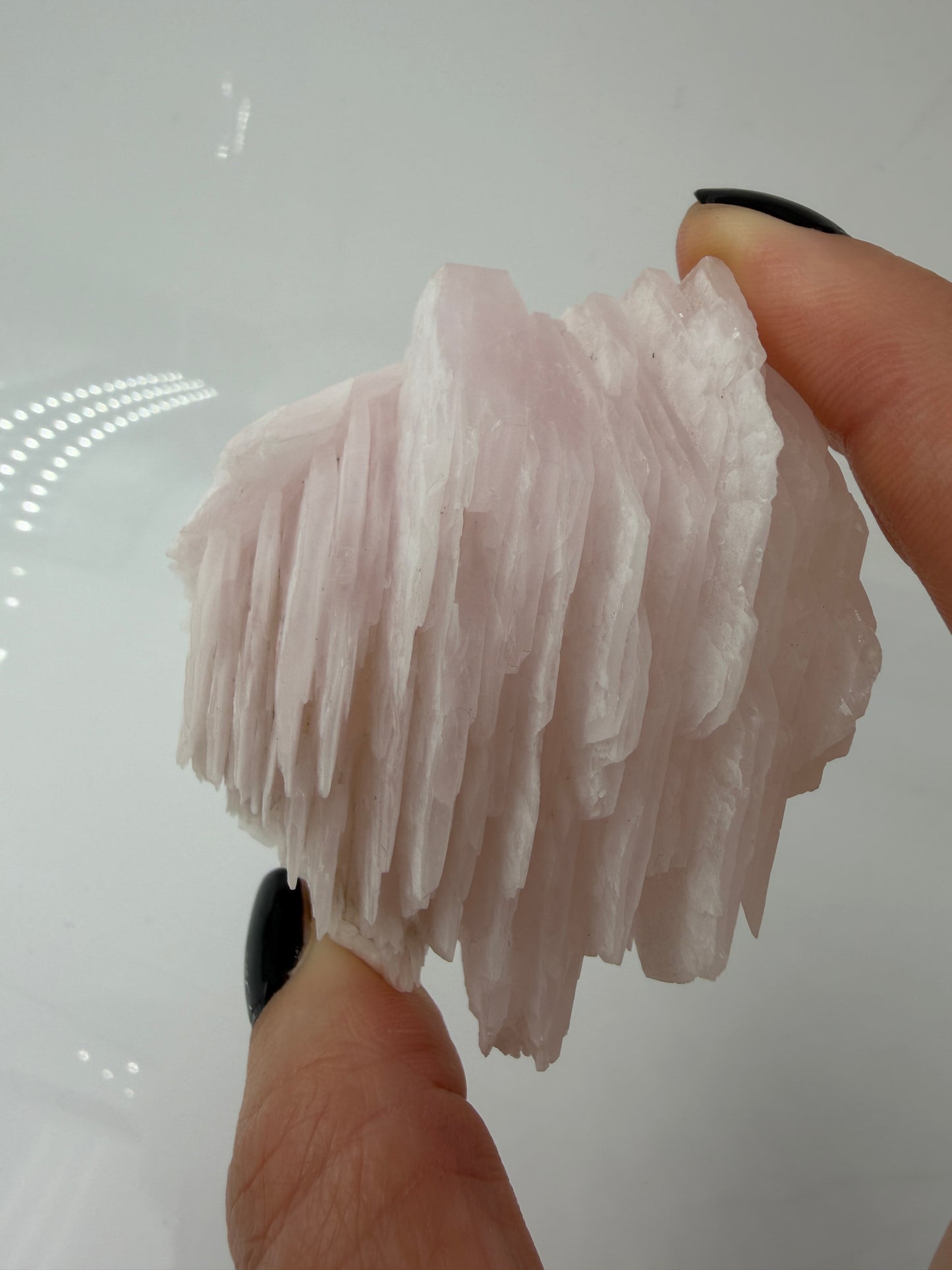 Naturbelassener Rohstein aus Mangano-Calcit in zartem Rosa mit sichtbaren Spaltflächen.
