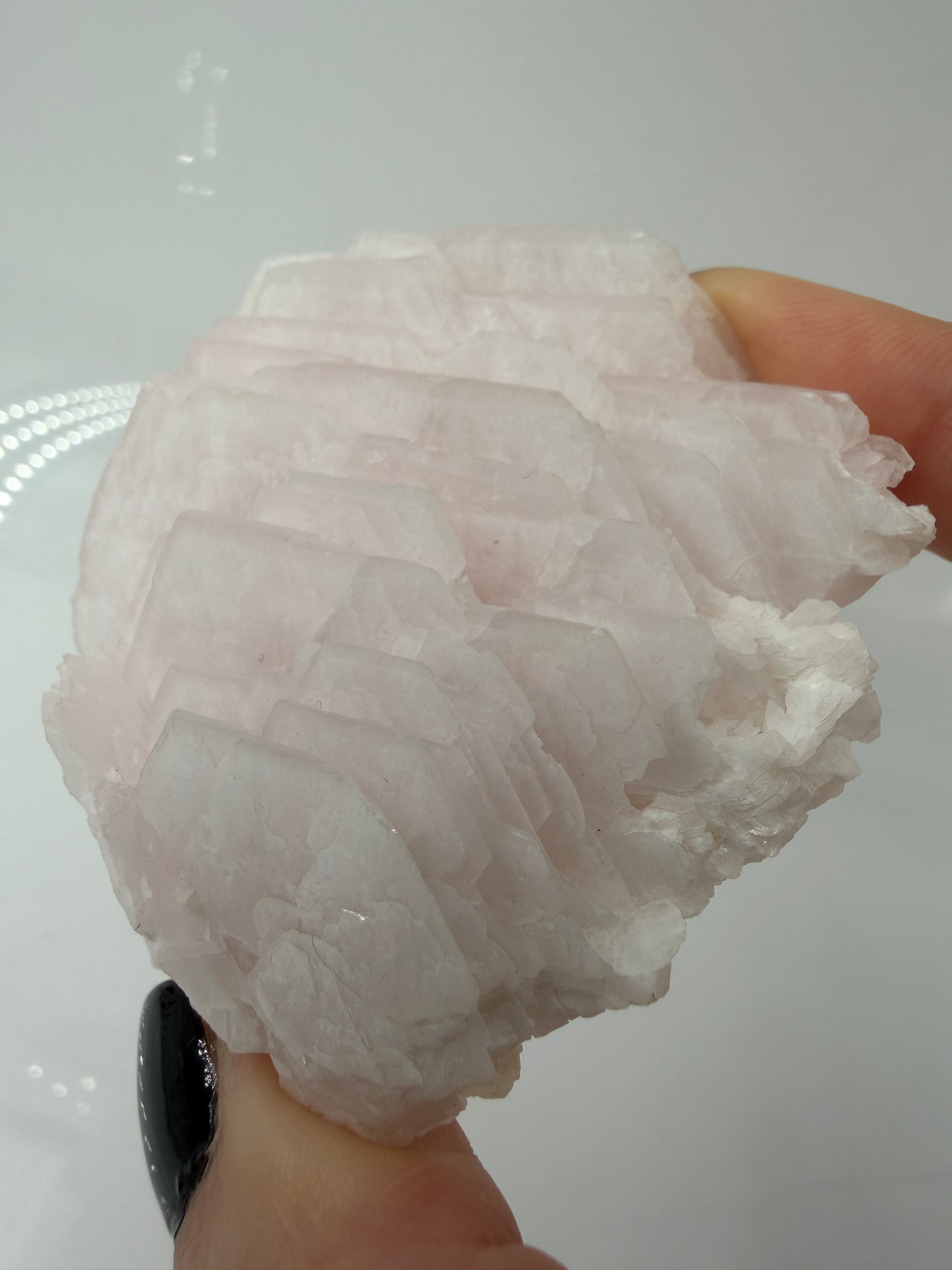 Naturbelassener Rohstein aus Mangano-Calcit in zartem Rosa mit sichtbaren Spaltflächen.