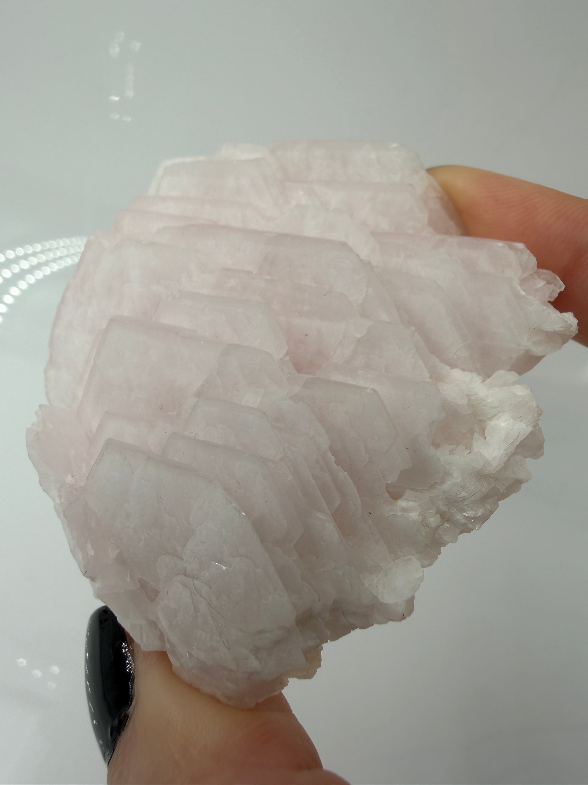 Naturbelassener Rohstein aus Mangano-Calcit in zartem Rosa mit sichtbaren Spaltflächen.
