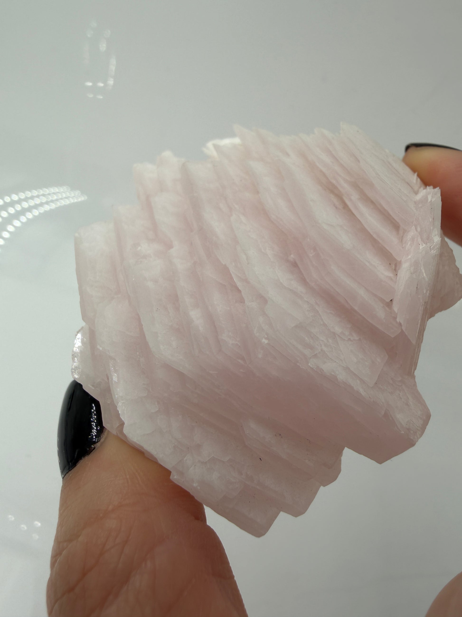 Naturbelassener Rohstein aus Mangano-Calcit in zartem Rosa mit sichtbaren Spaltflächen.